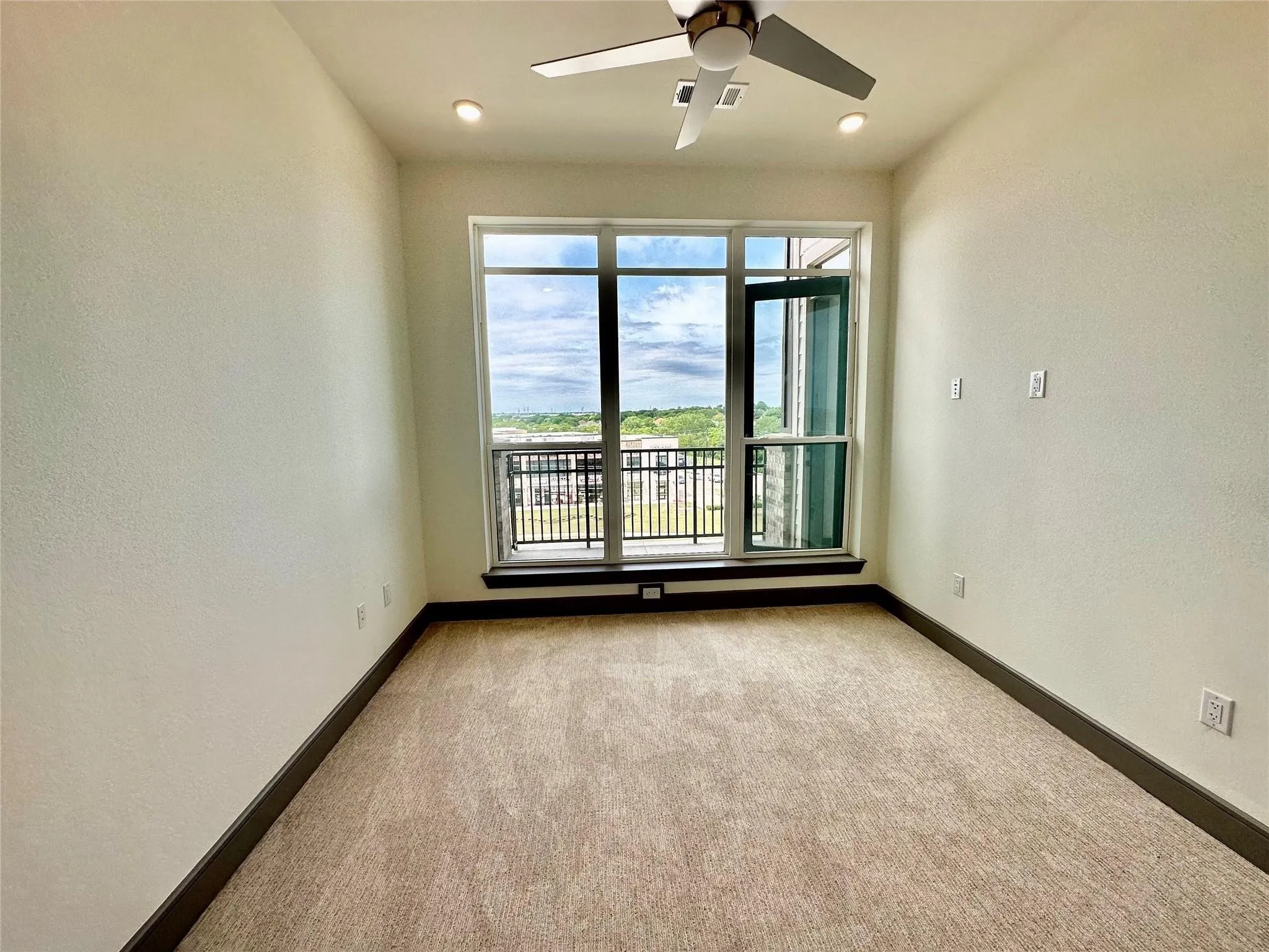 Room with full-height windows and a balcony door