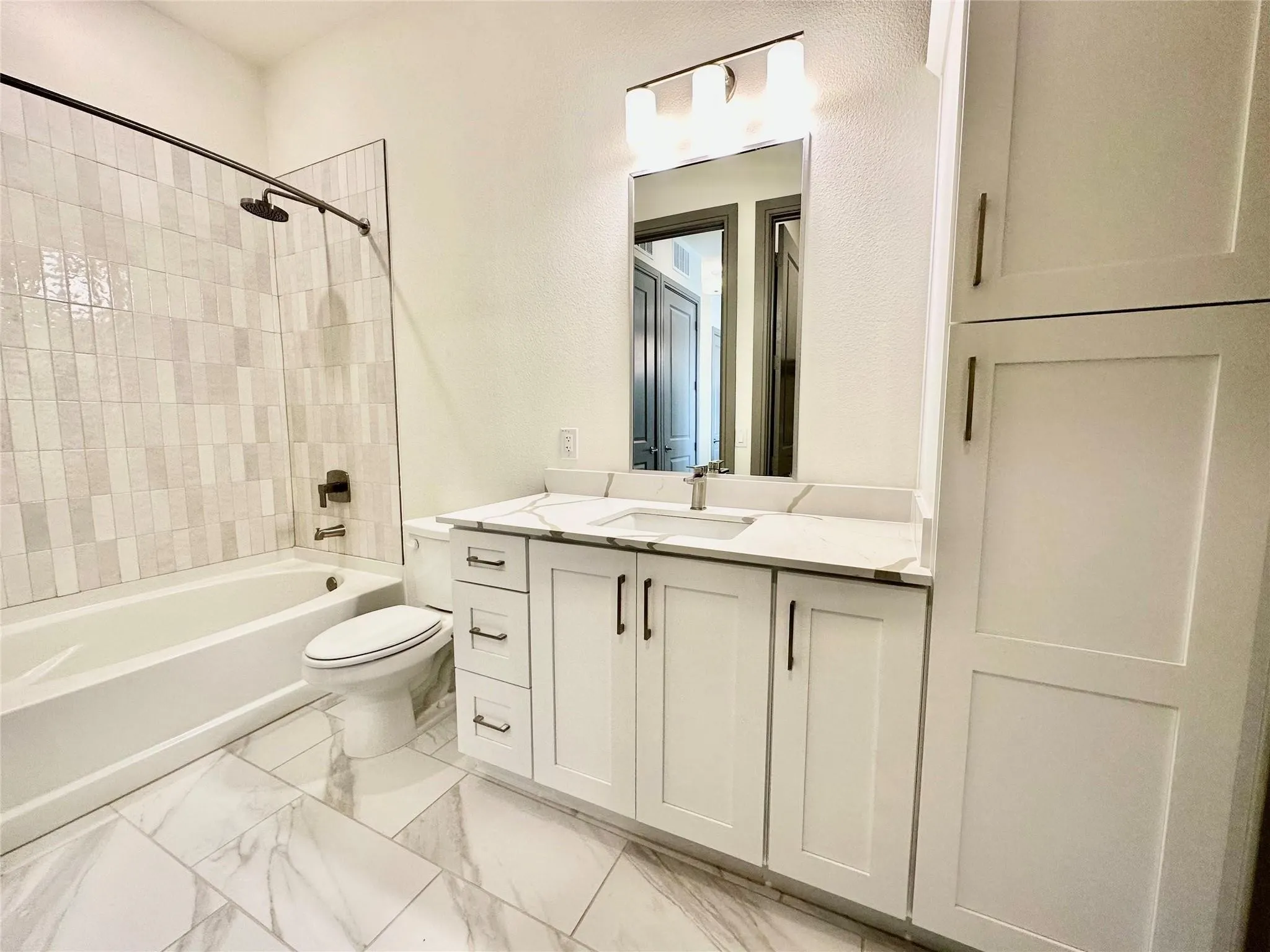 Bathroom featuring a white vanity with a light countertop, integrated sink, and dark hardware
