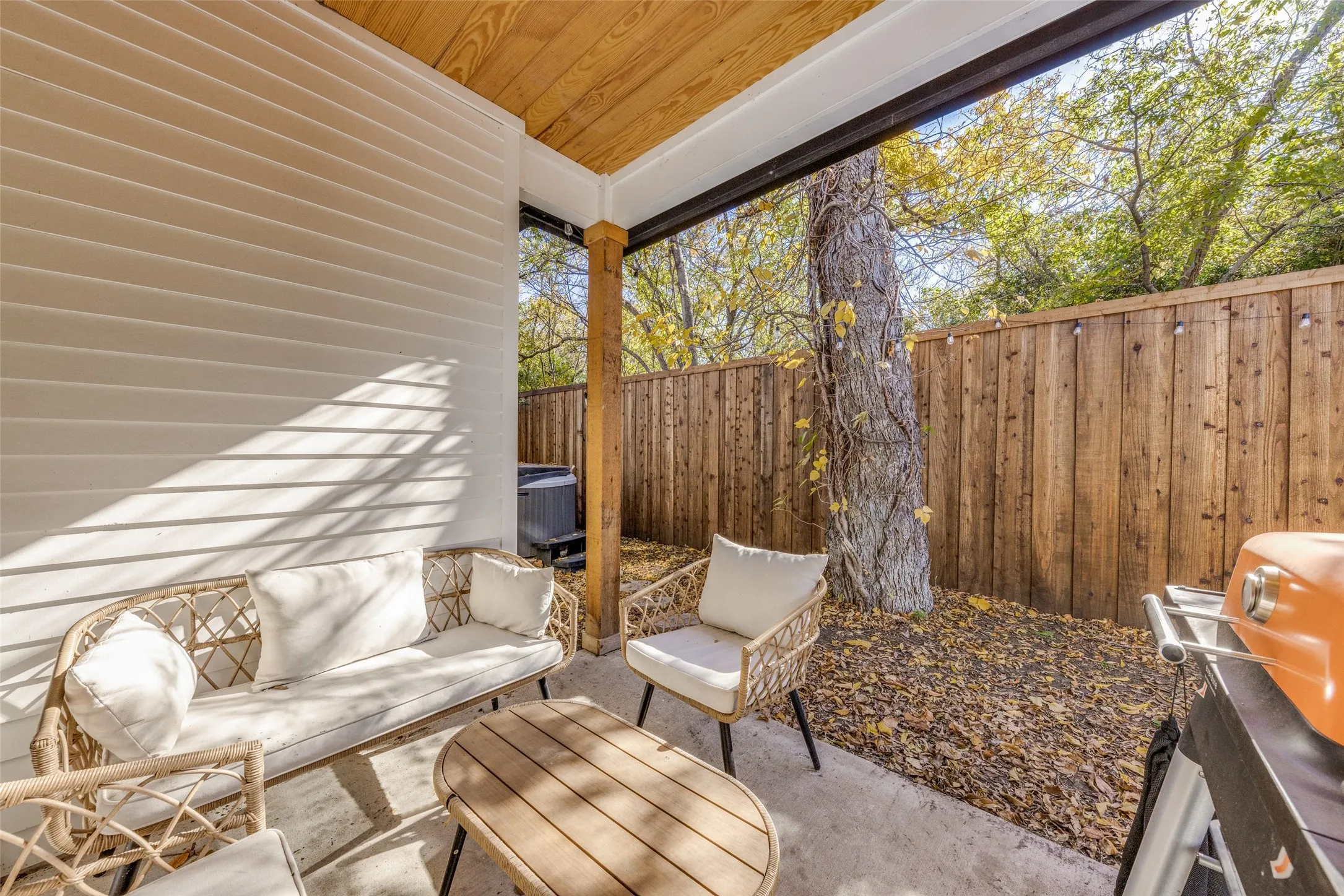 Private outdoor patio featuring a concrete slab and wood fence