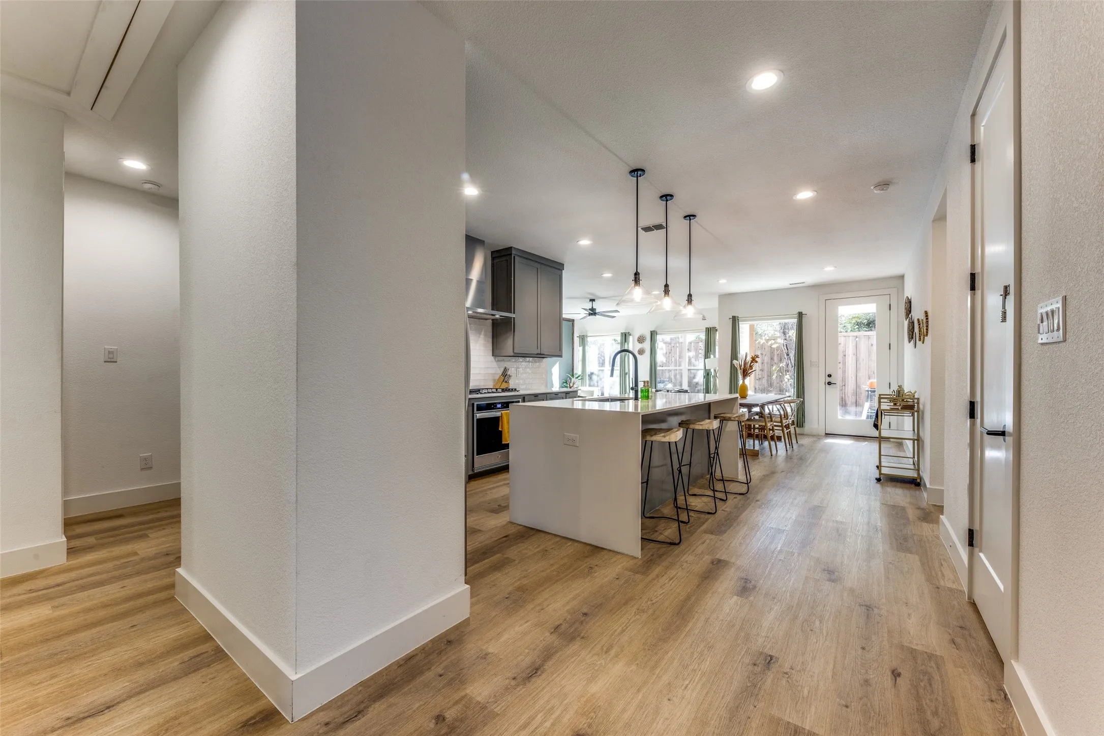 Open concept living area featuring wood-finish flooring, recessed lighting, and a contemporary kitchen