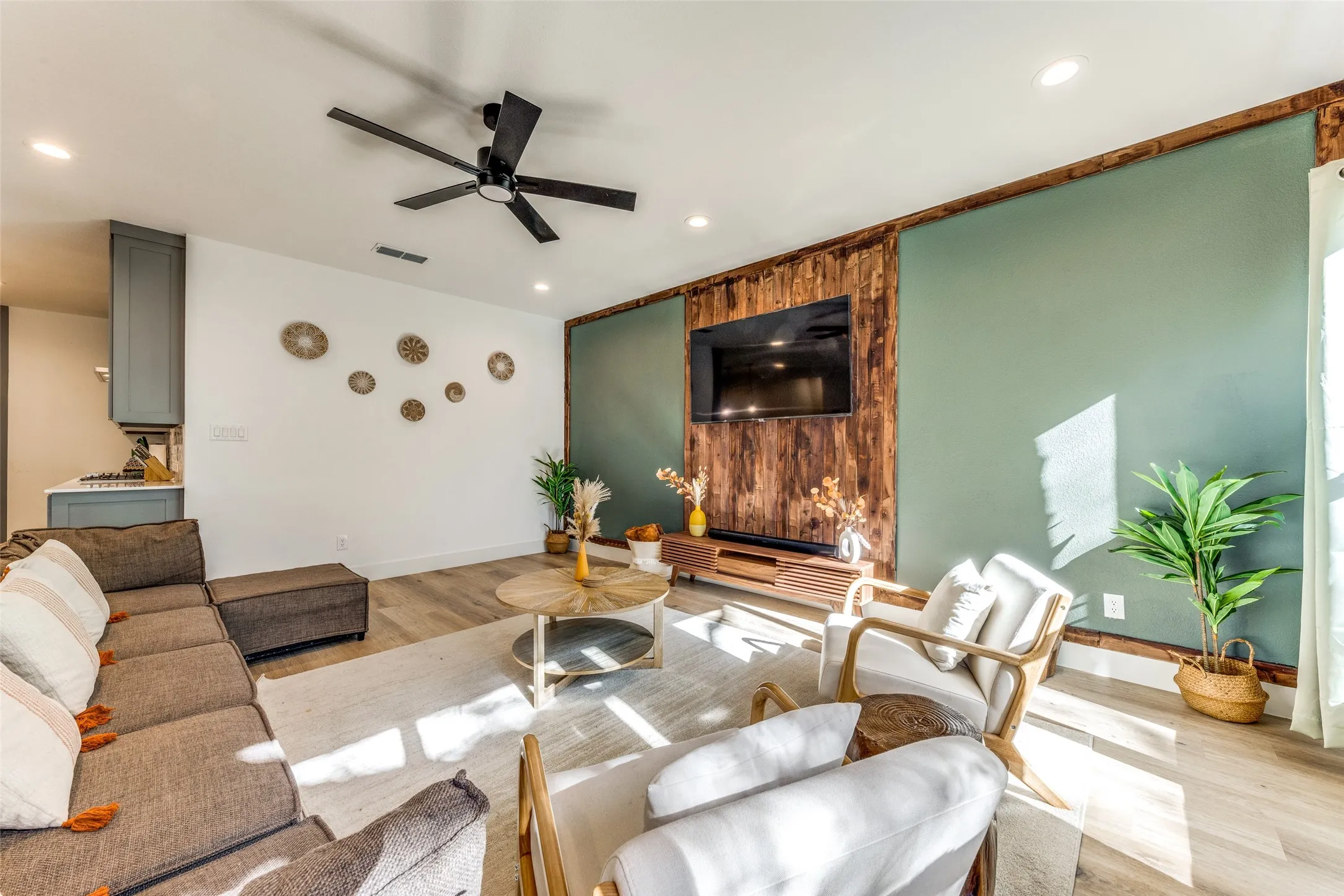 Living space featuring wood-finish flooring, recessed lighting, and a black ceiling fan