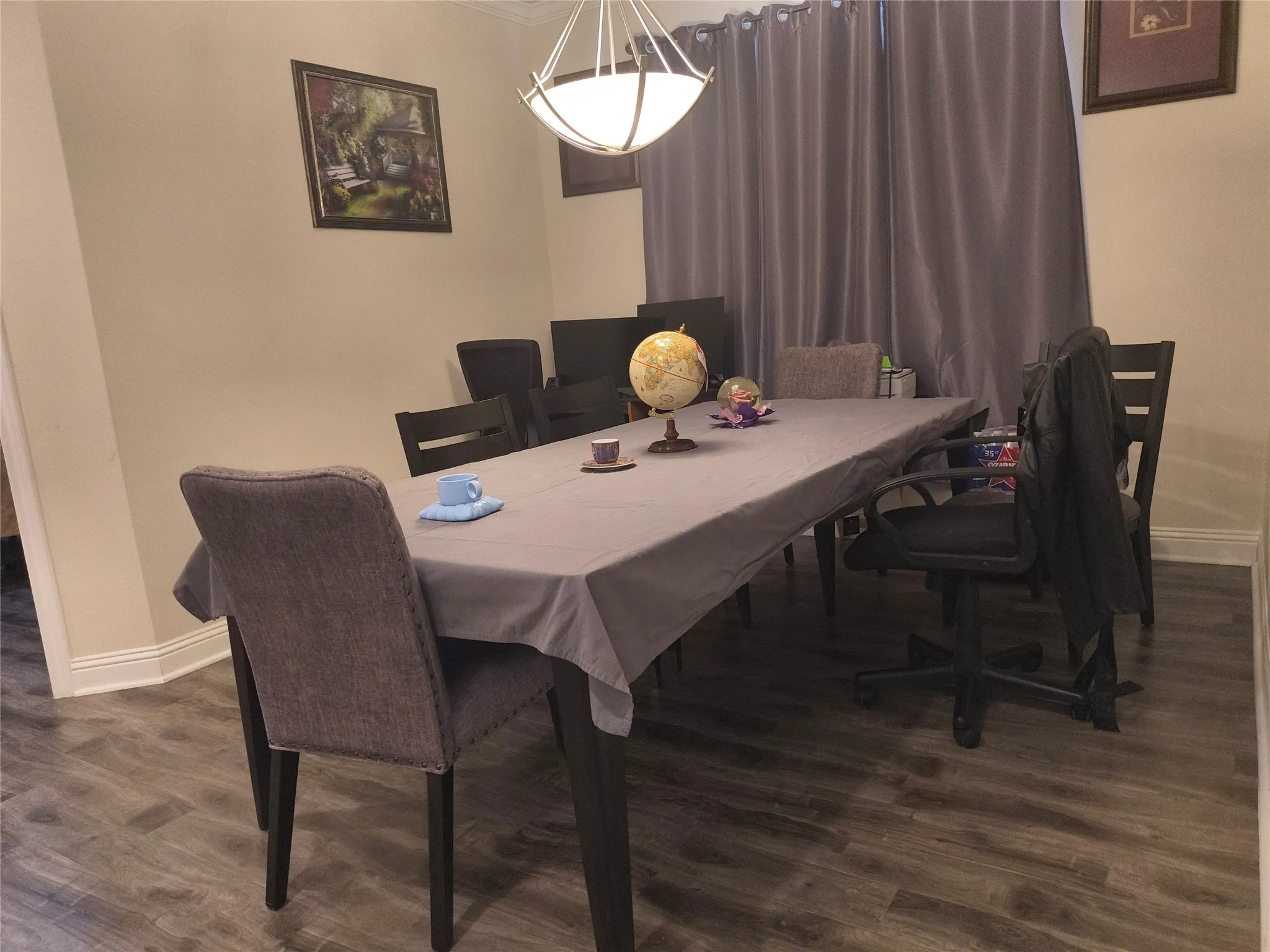 Dining area featuring wood-finish flooring, neutral wall tones, and crown molding