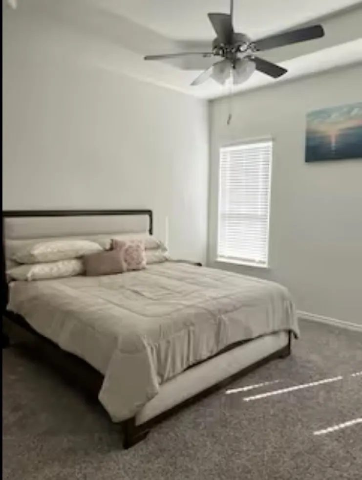 Primary Bedroom featuring a ceiling fan and carpet