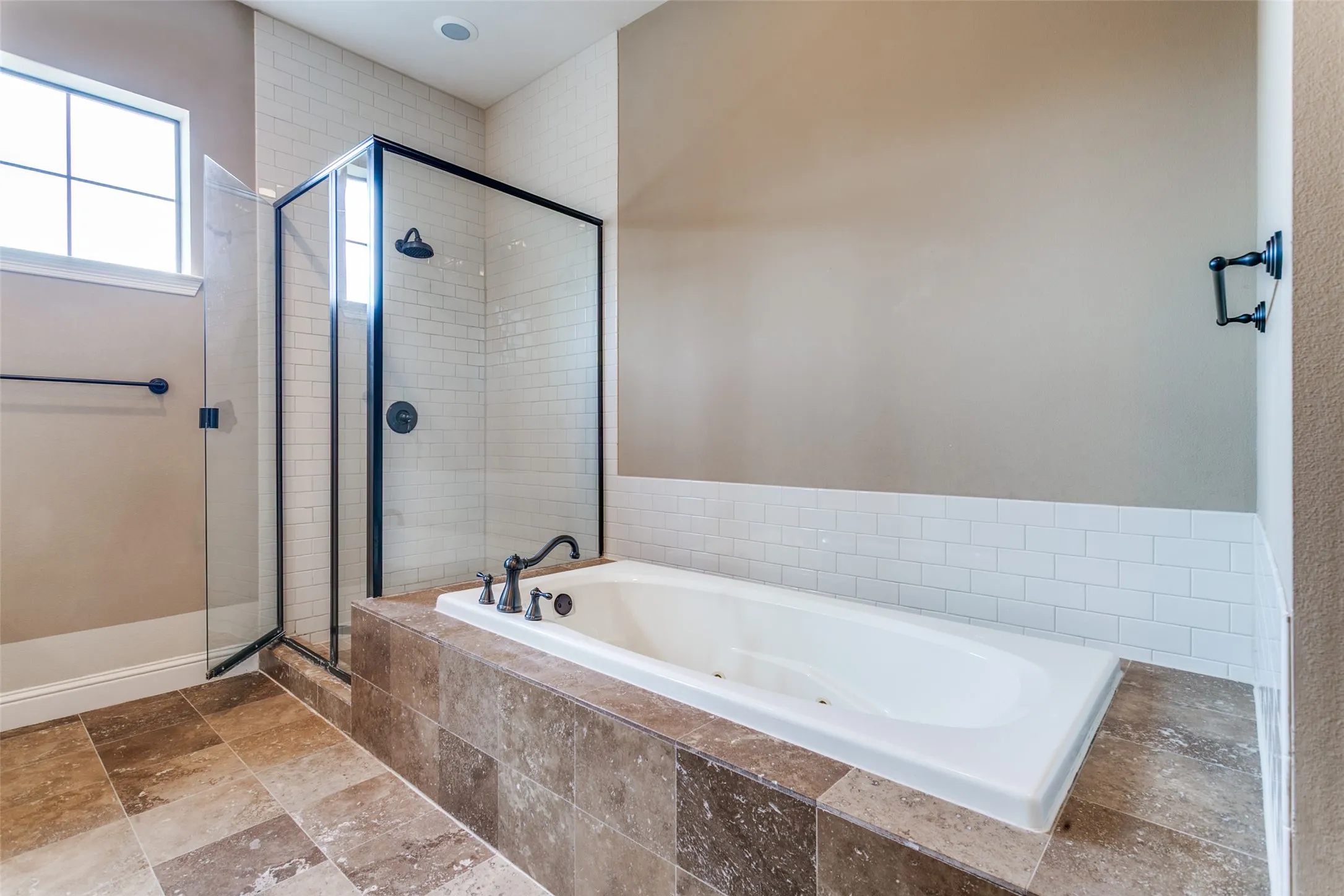 Primary bath featuring a large tub and separate walk in shower.