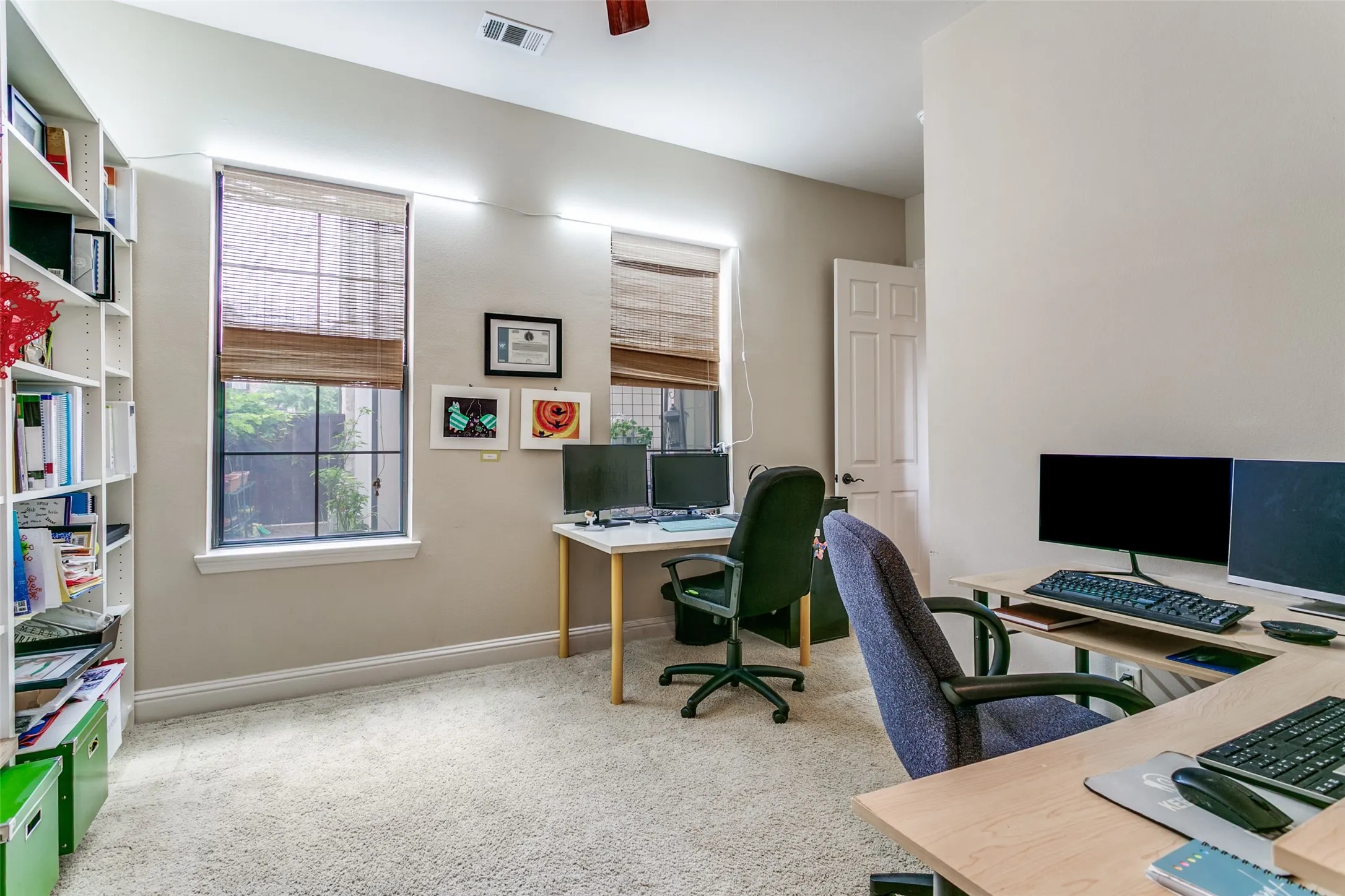 Bedroom currently used as an office, featuring courtyard views and a spacious walk-in closet.