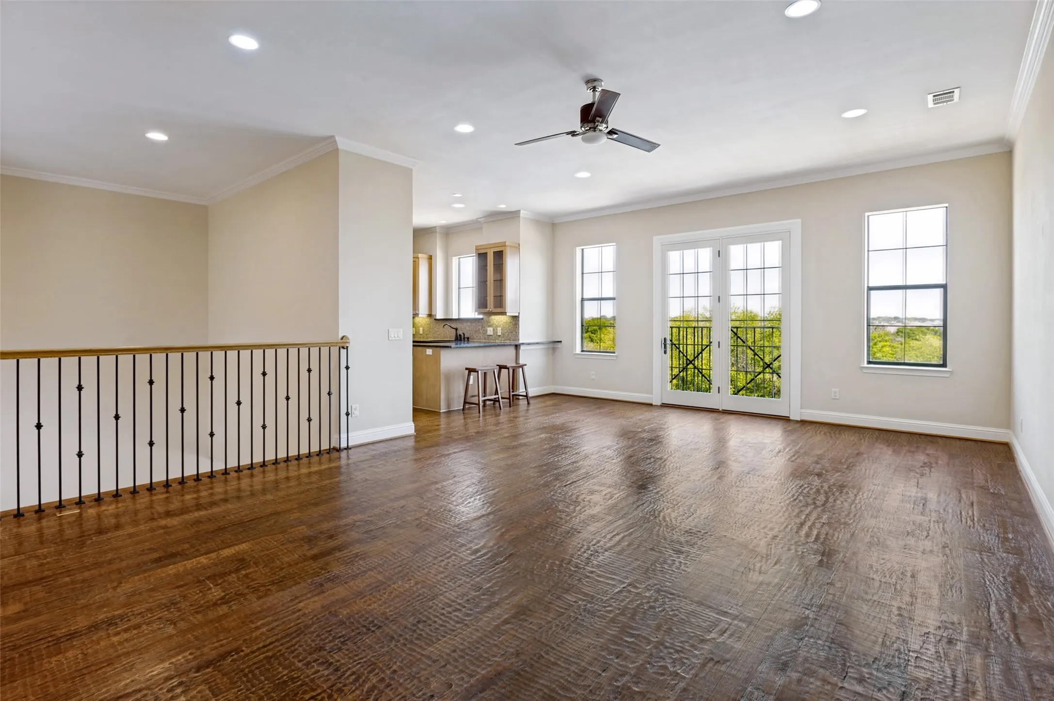 Expansive living room featuring hand-scraped wood flooring, abundant natural light and a flexible layout.