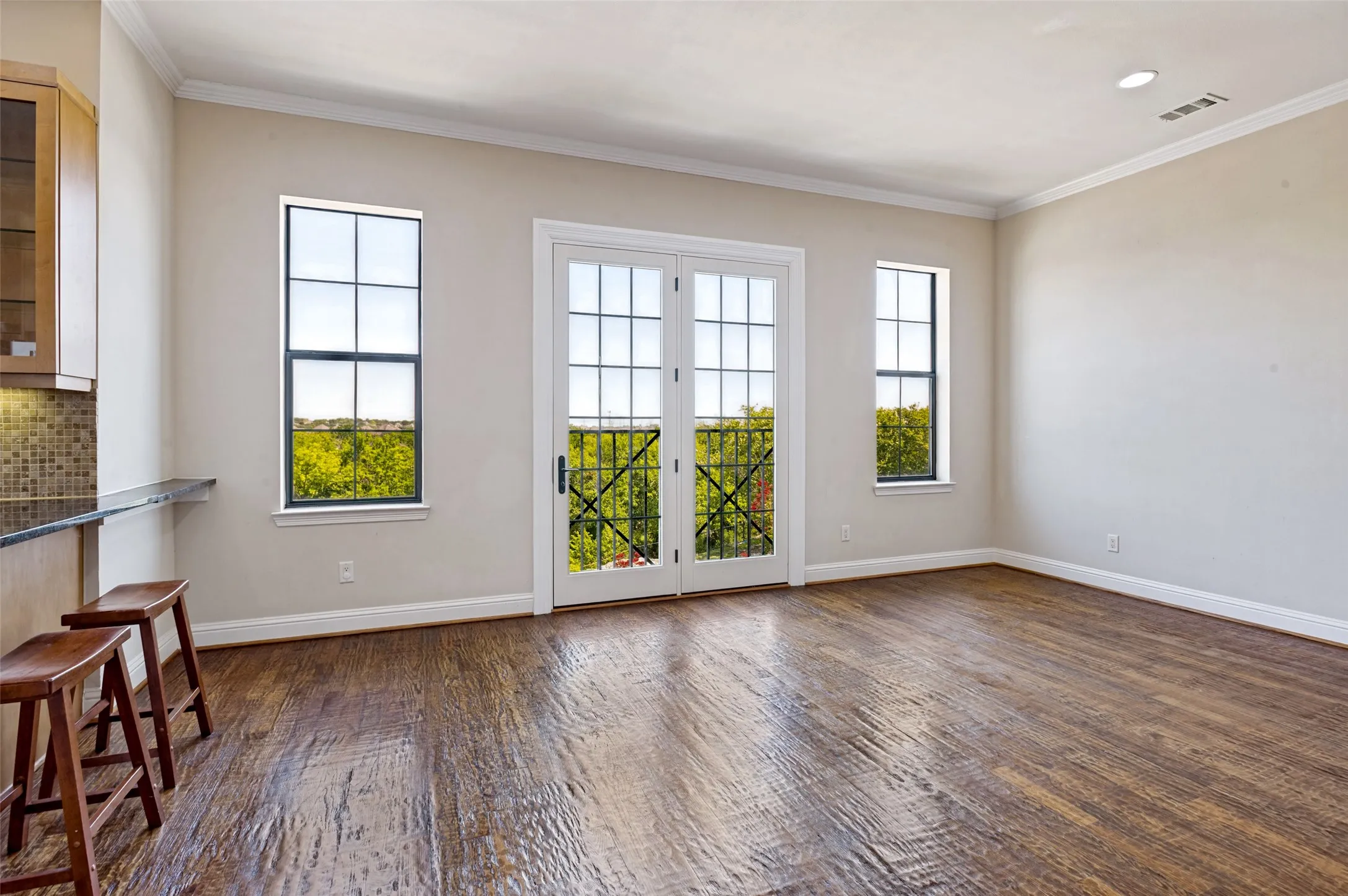 Dining room filled with natural light with windows overlooking green space.