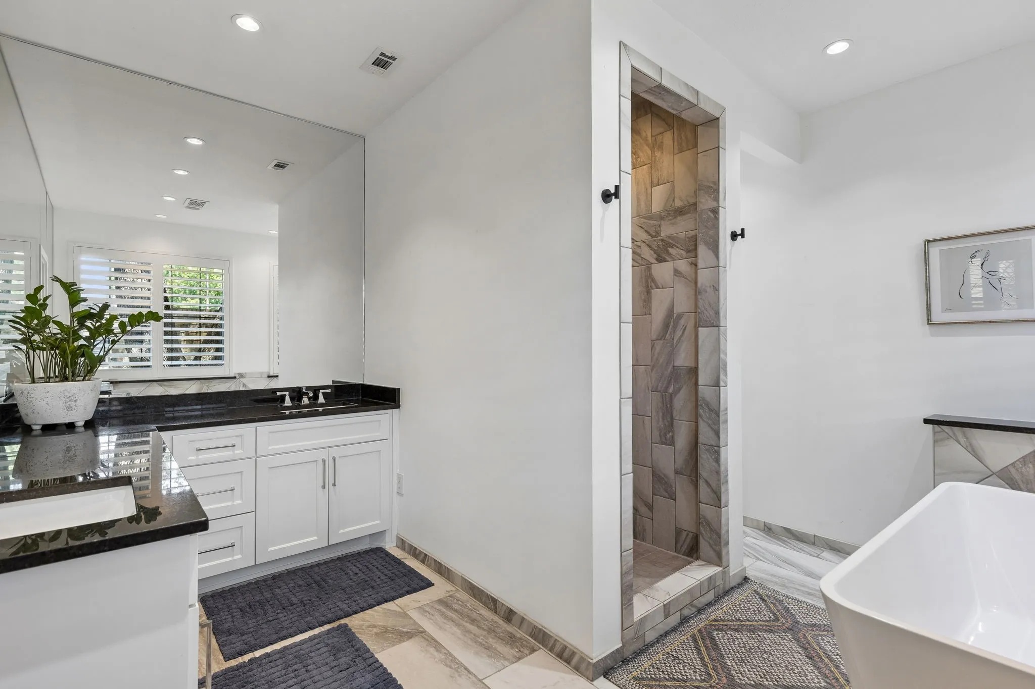 The primary bath is serene and spa like with free-standing tub, walk-in shower and great natural light.