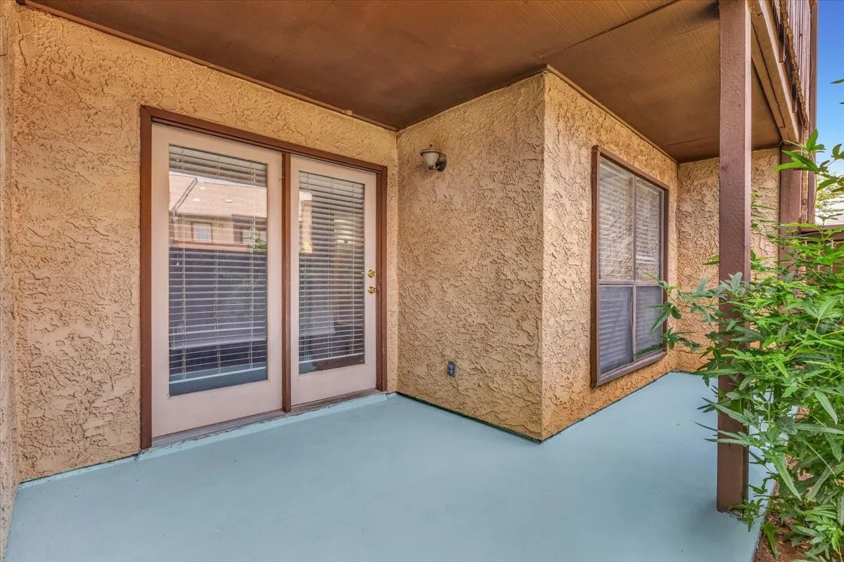 Covered patio with stucco-finish walls and light blue polished concrete flooring.