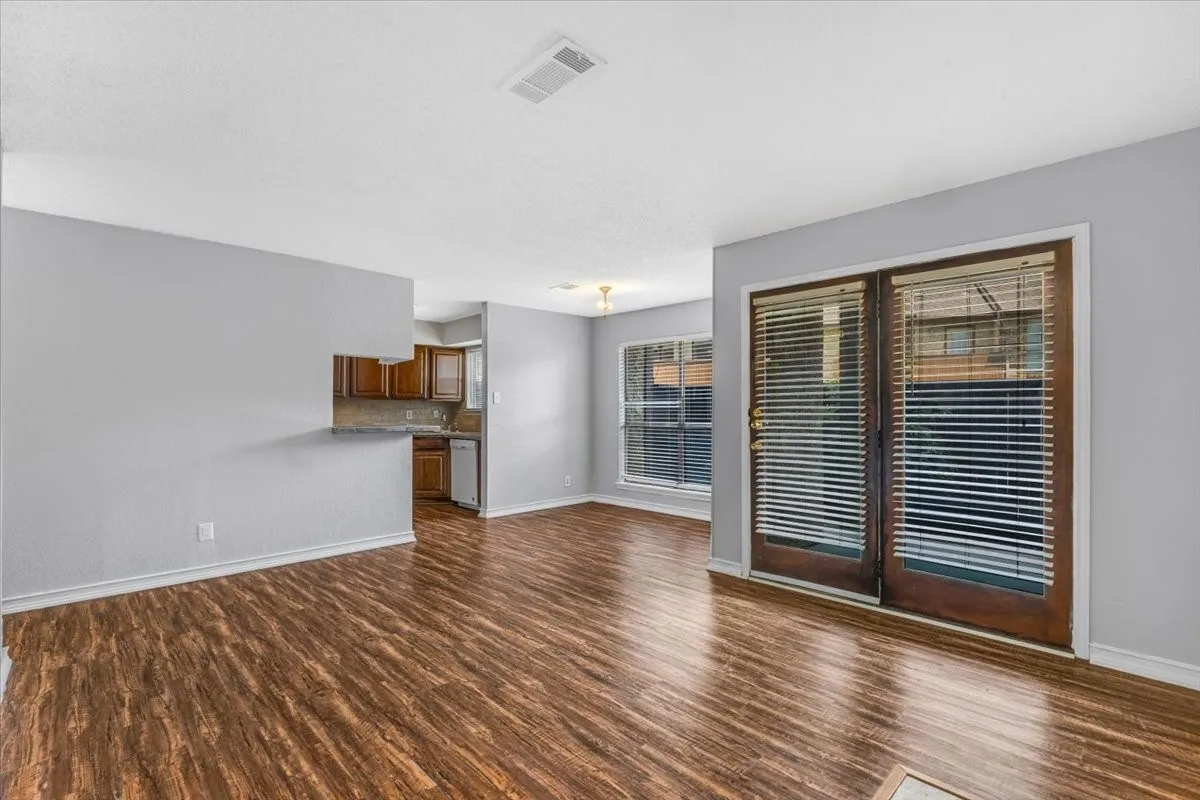 Fireplace with tile surround, wood-finish flooring, white walls, recessed ceiling lighting, and overhead lighting fixture.