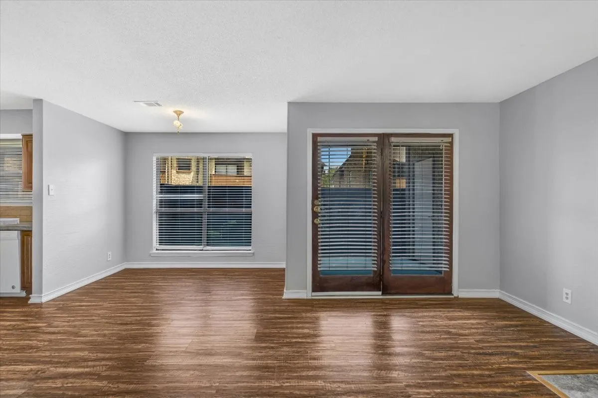 Fireplace with tile surround, wood-finish flooring, white walls, recessed ceiling lighting, and overhead lighting fixture.