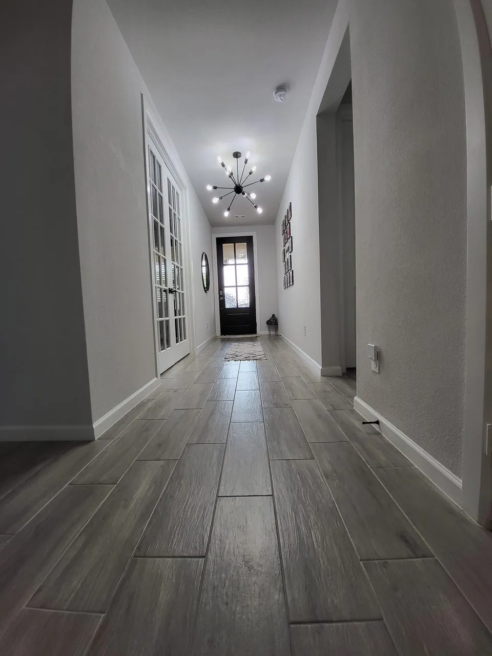 Corridor featuring a notable chandelier