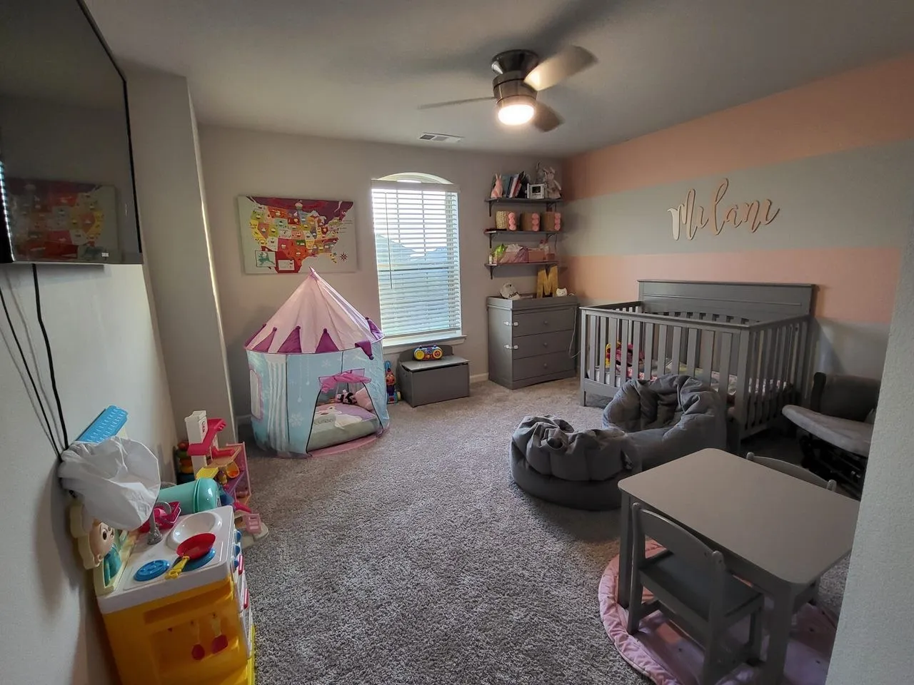 Bedroom featuring carpet, a crib, and ceiling fan