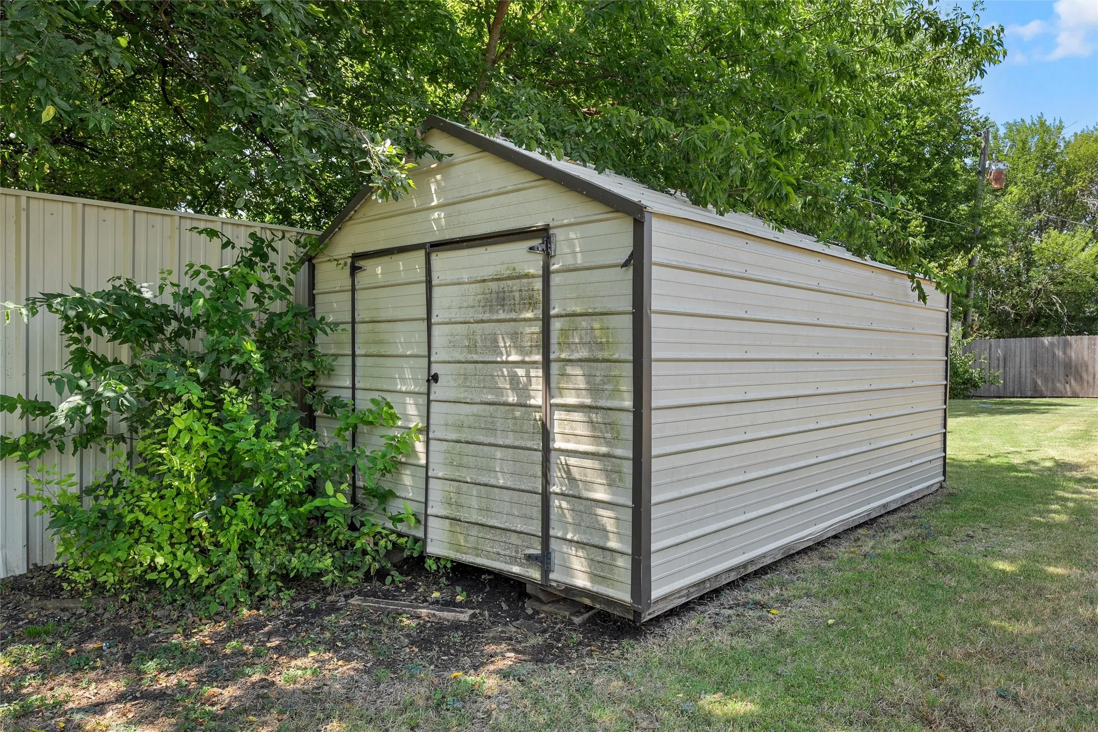 Metal storage shed with a peaked roof and double doors