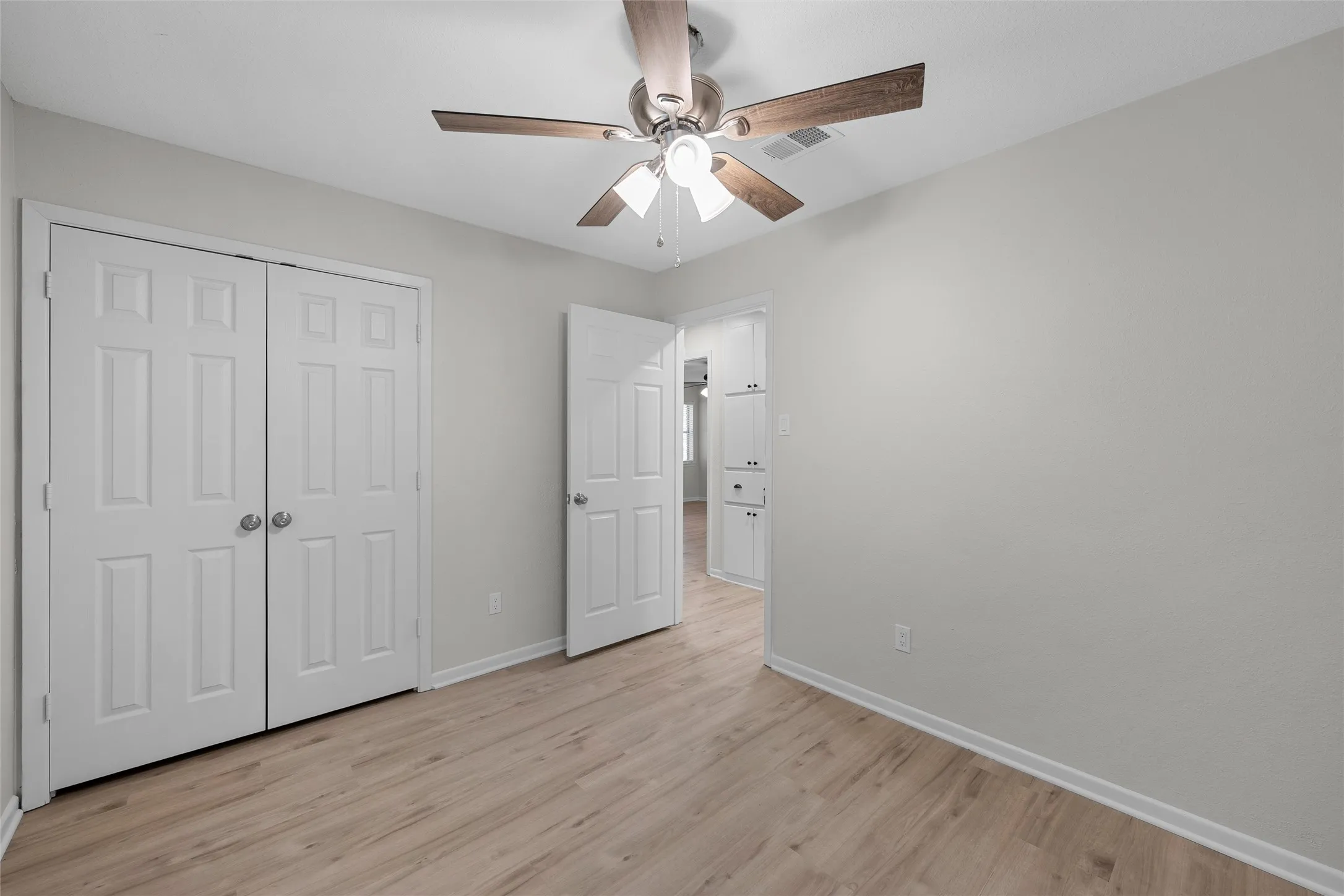 Room featuring light wood-finish flooring, white baseboards, and neutral wall tones