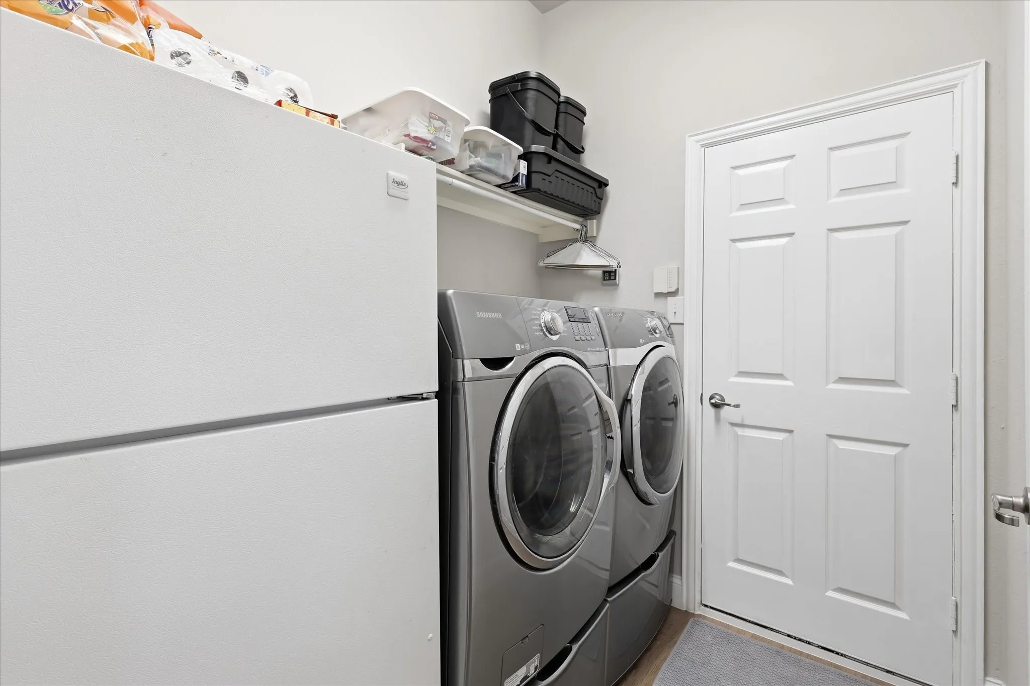 Laundry area featuring a built-in shelf, two doors with paneling, and light-colored walls