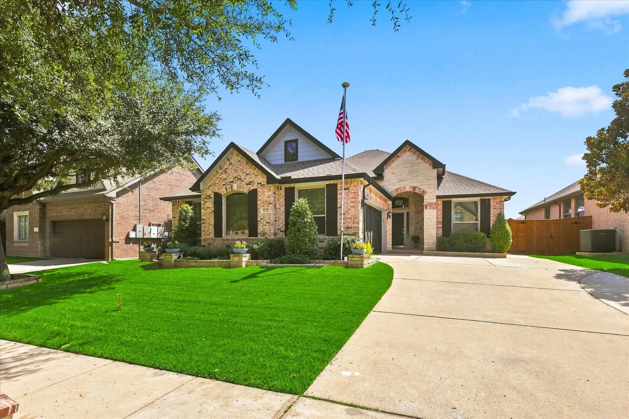 Brick and stone veneer exterior with dark shingle roofing
