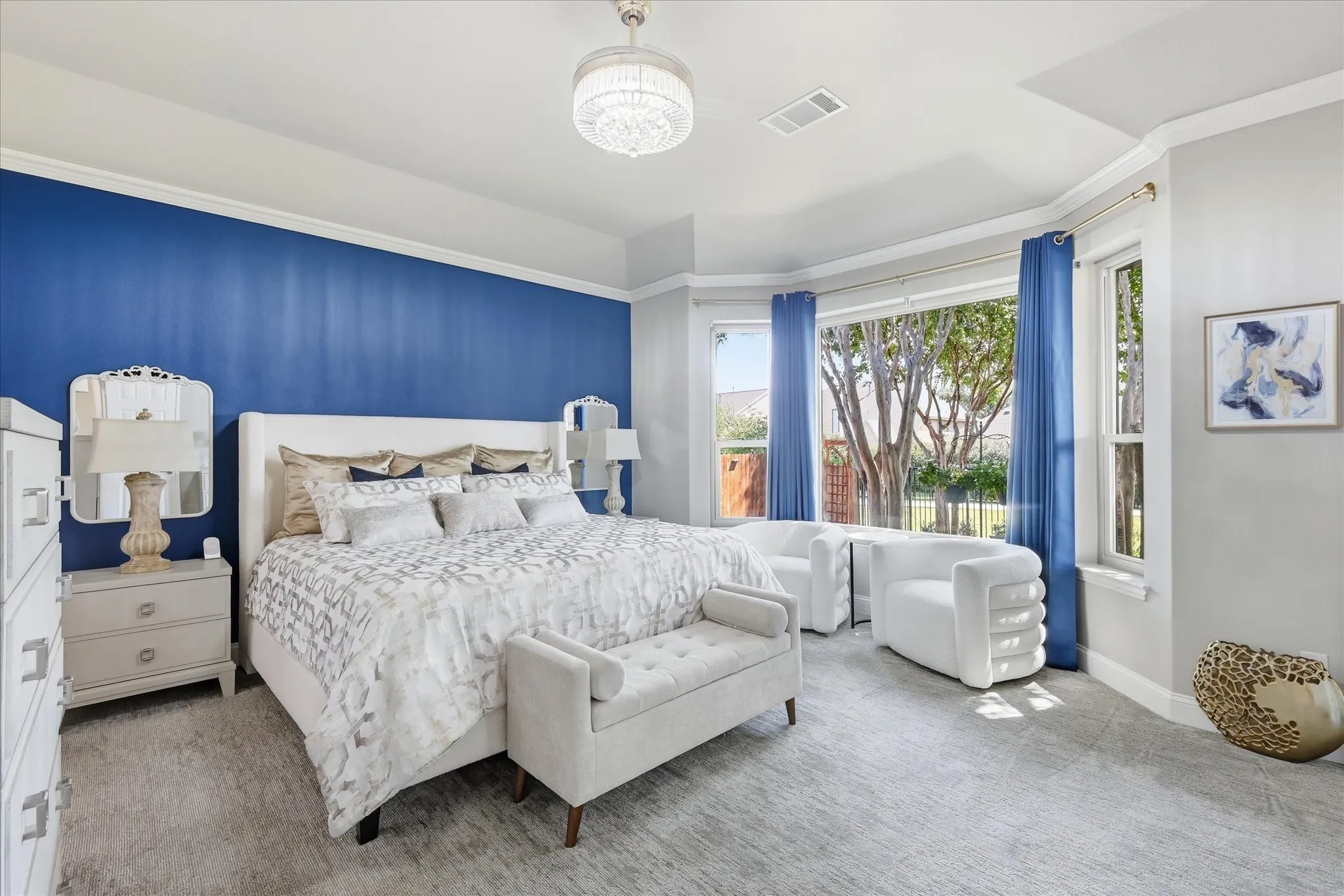 Recessed ceiling with a chandelier, bay window, and gray carpeted flooring