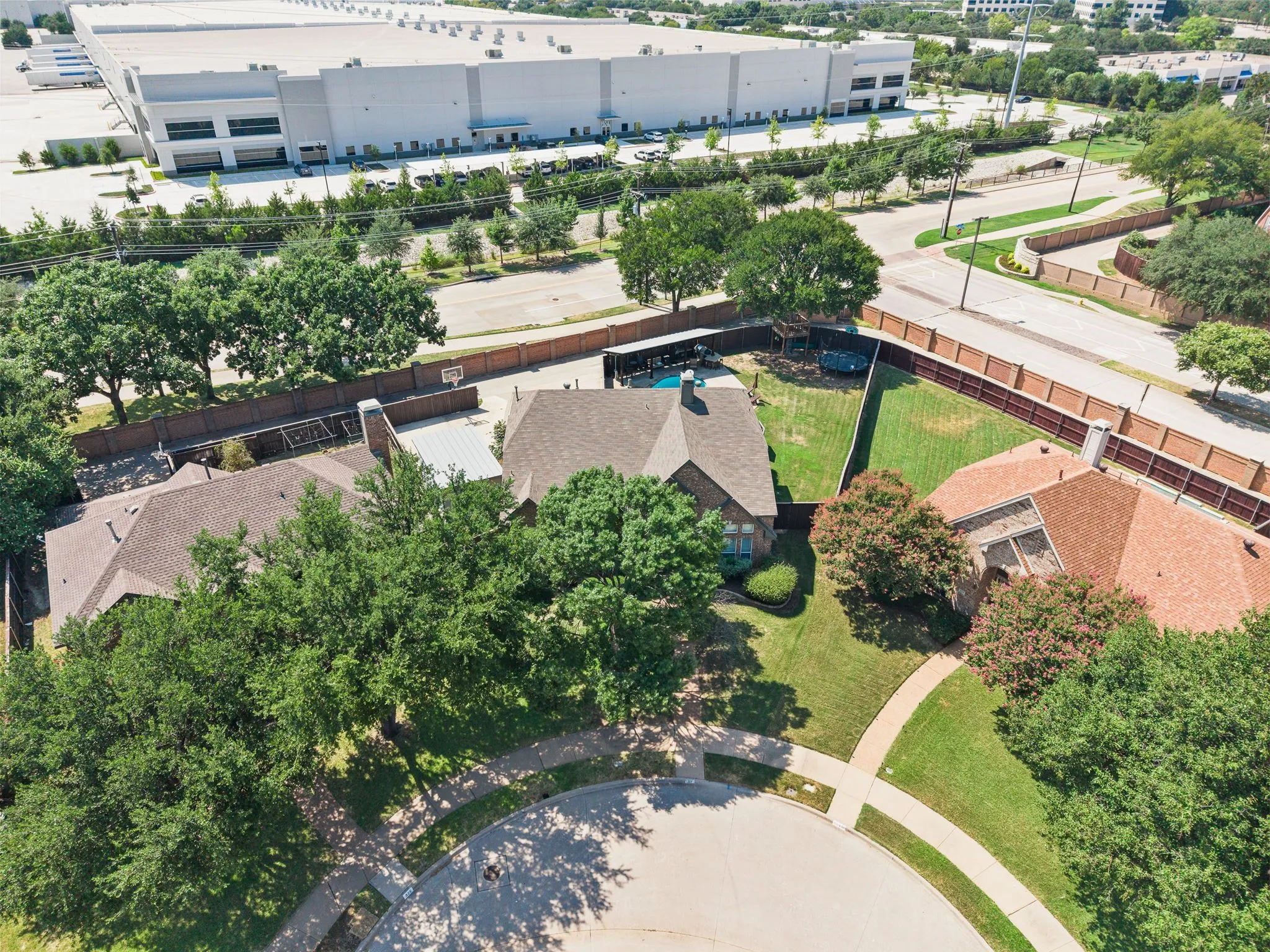 Expansive property featuring a private swimming pool, mature trees, manicured lawns, and a cul-de-sac street