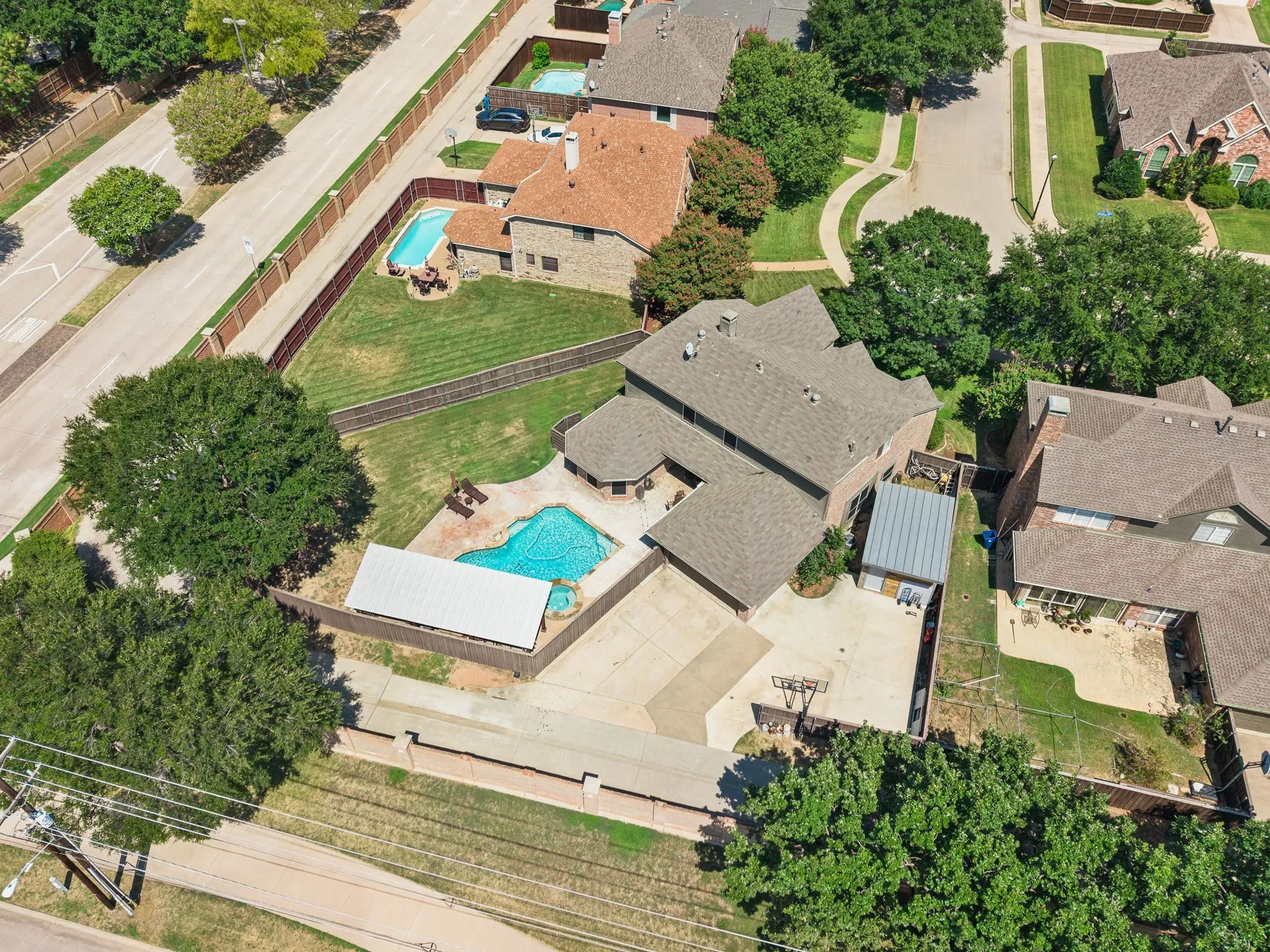Property with an irregular-shaped pool, an additional rectangular pool, and a covered patio area, extra parking pad for boat/rv, and man cave or storage building with electric