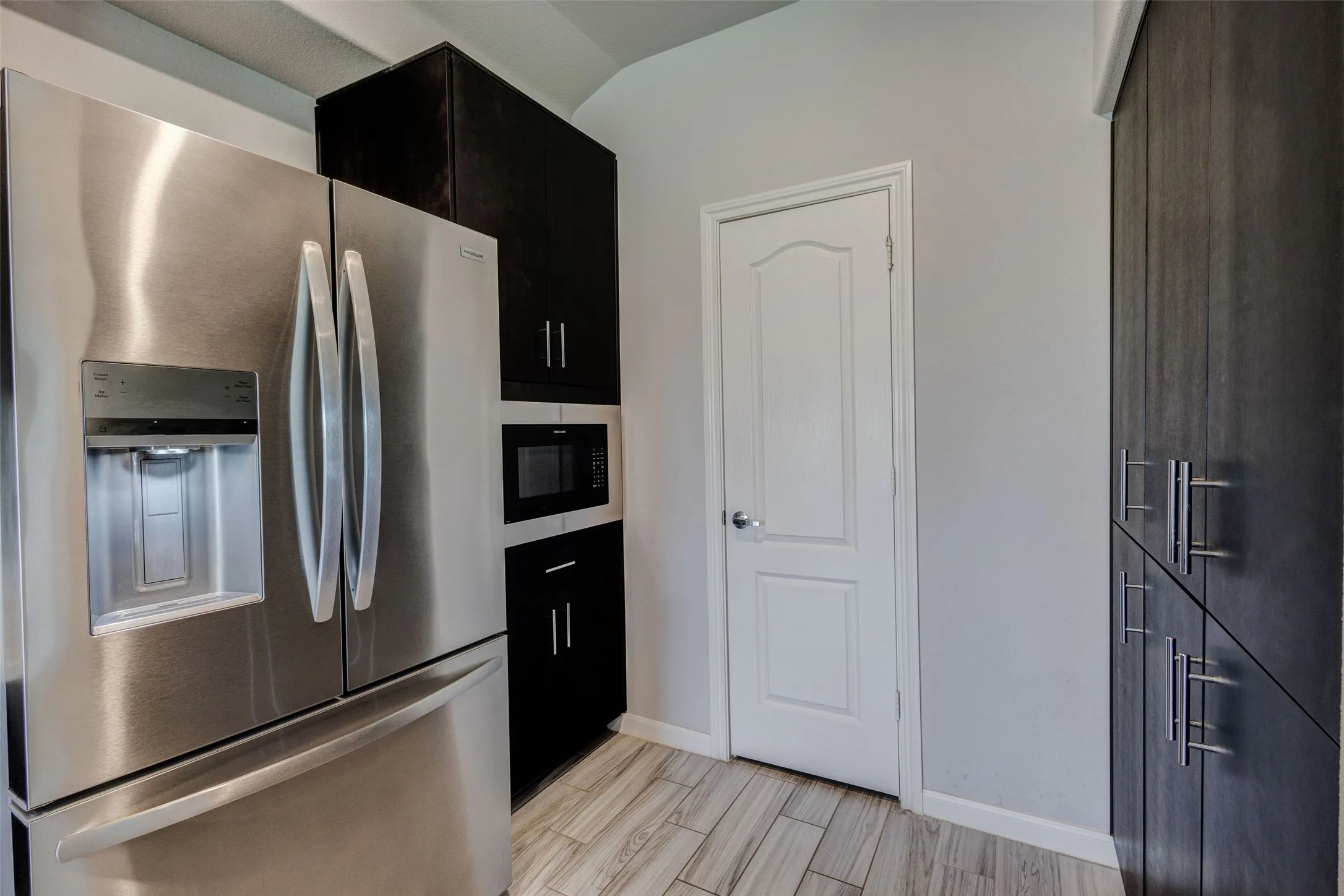 Stainless steel French door refrigerator with an integrated ice and water dispenser