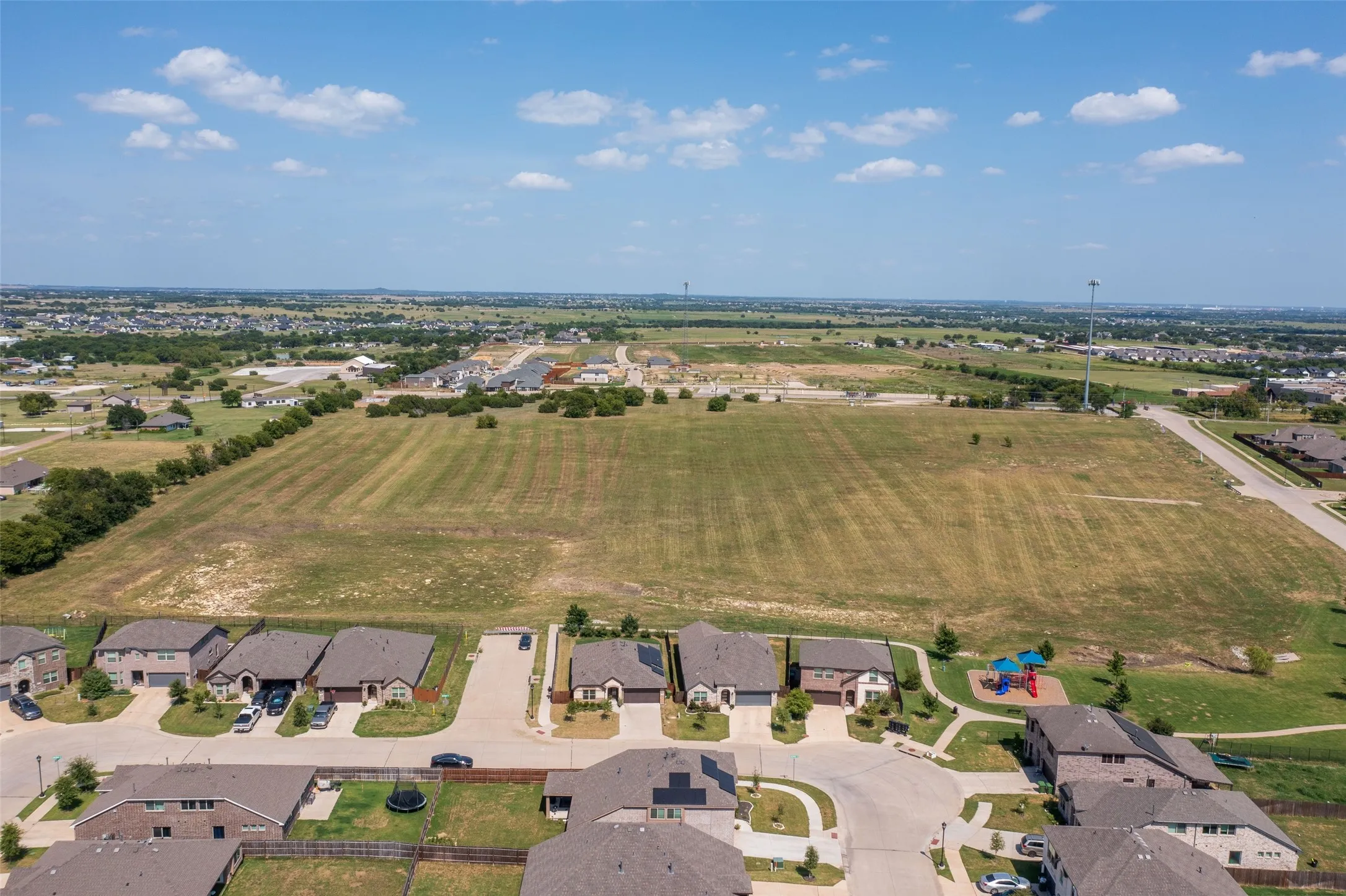 Aerial depiction of a neighborhood featuring residential properties and undeveloped land