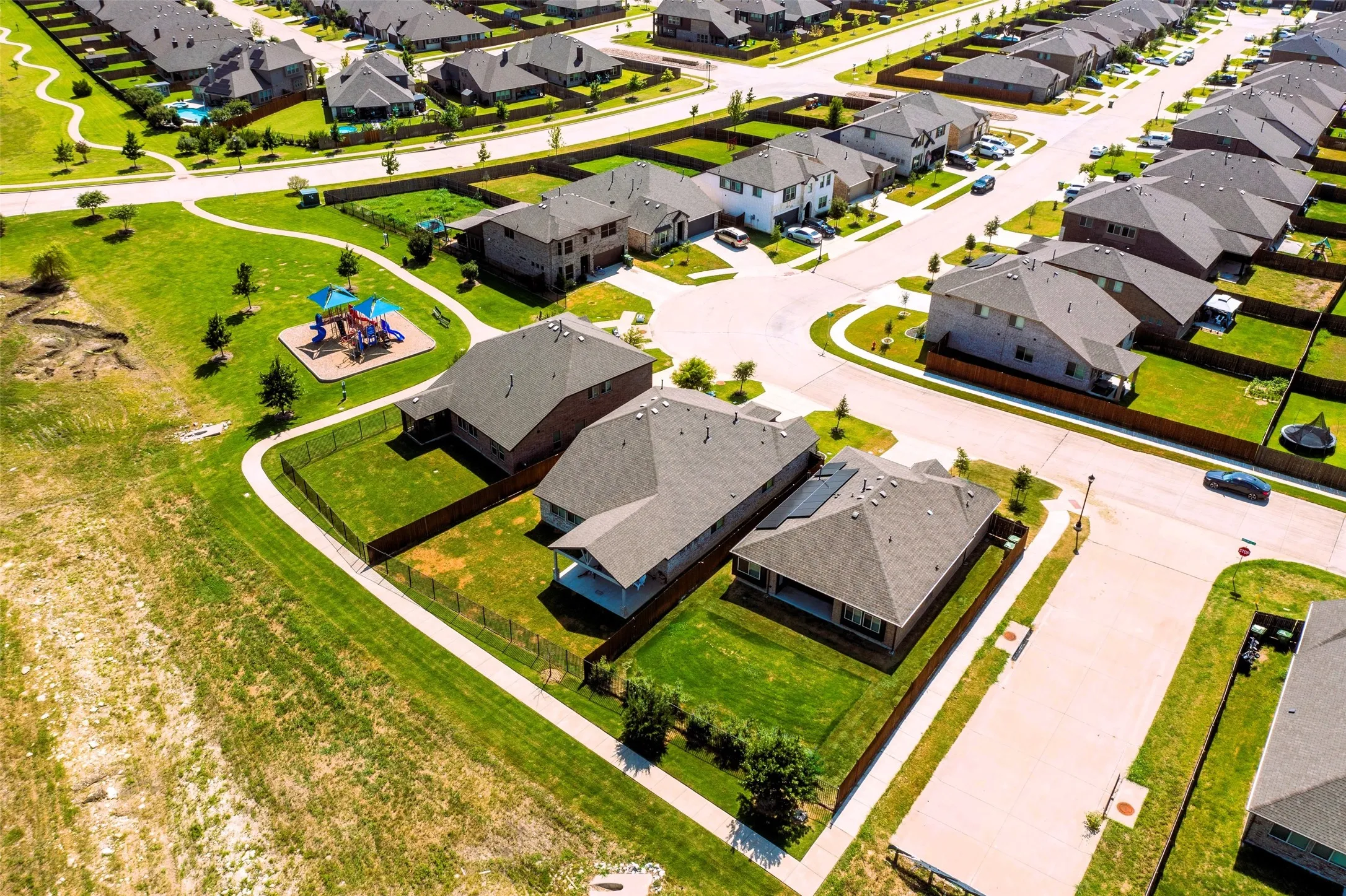 Aerial view of a residential neighborhood featuring multiple single-family homes with gray shingle roofs