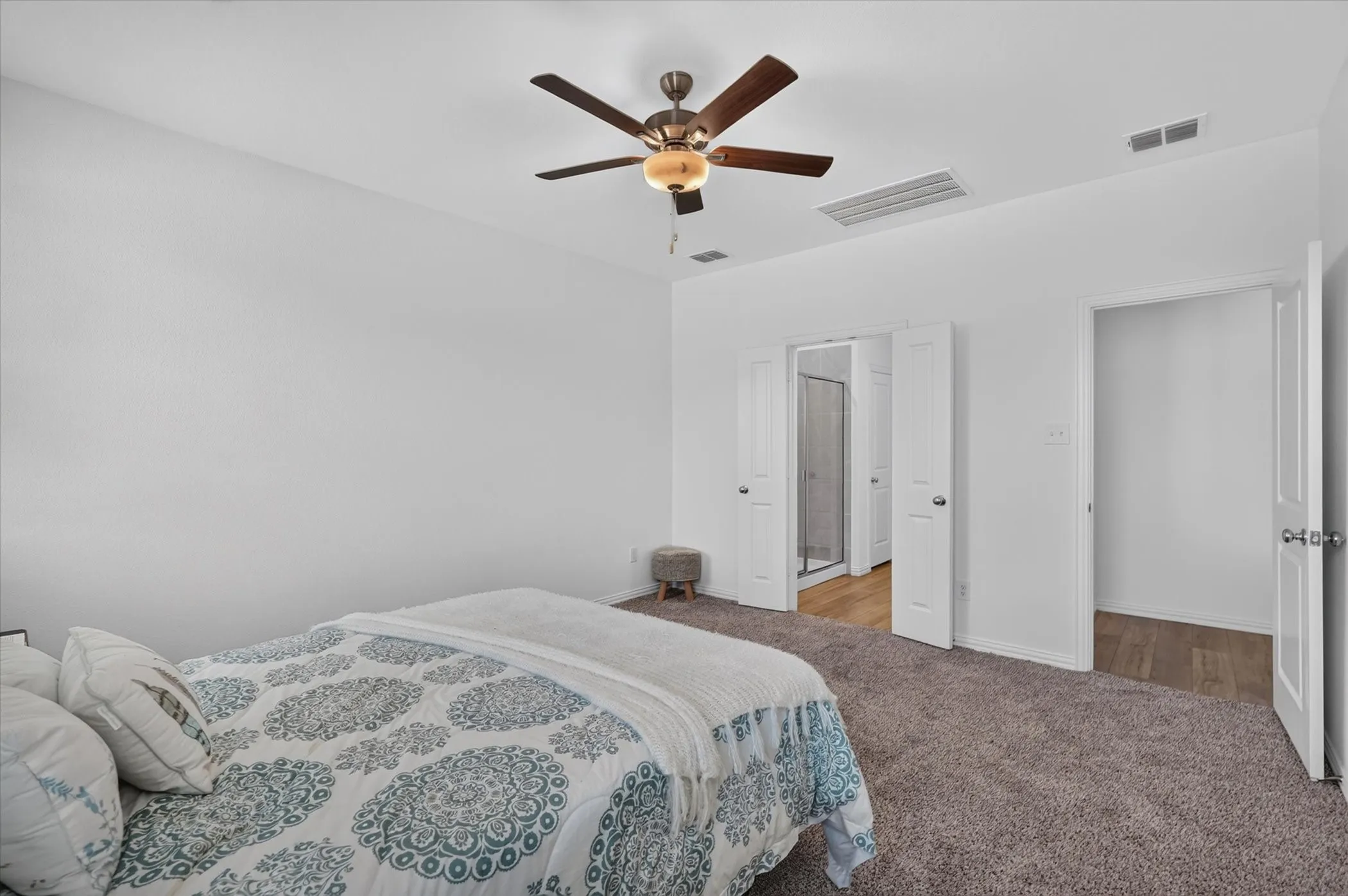 Carpeted bedroom with a ceiling fan