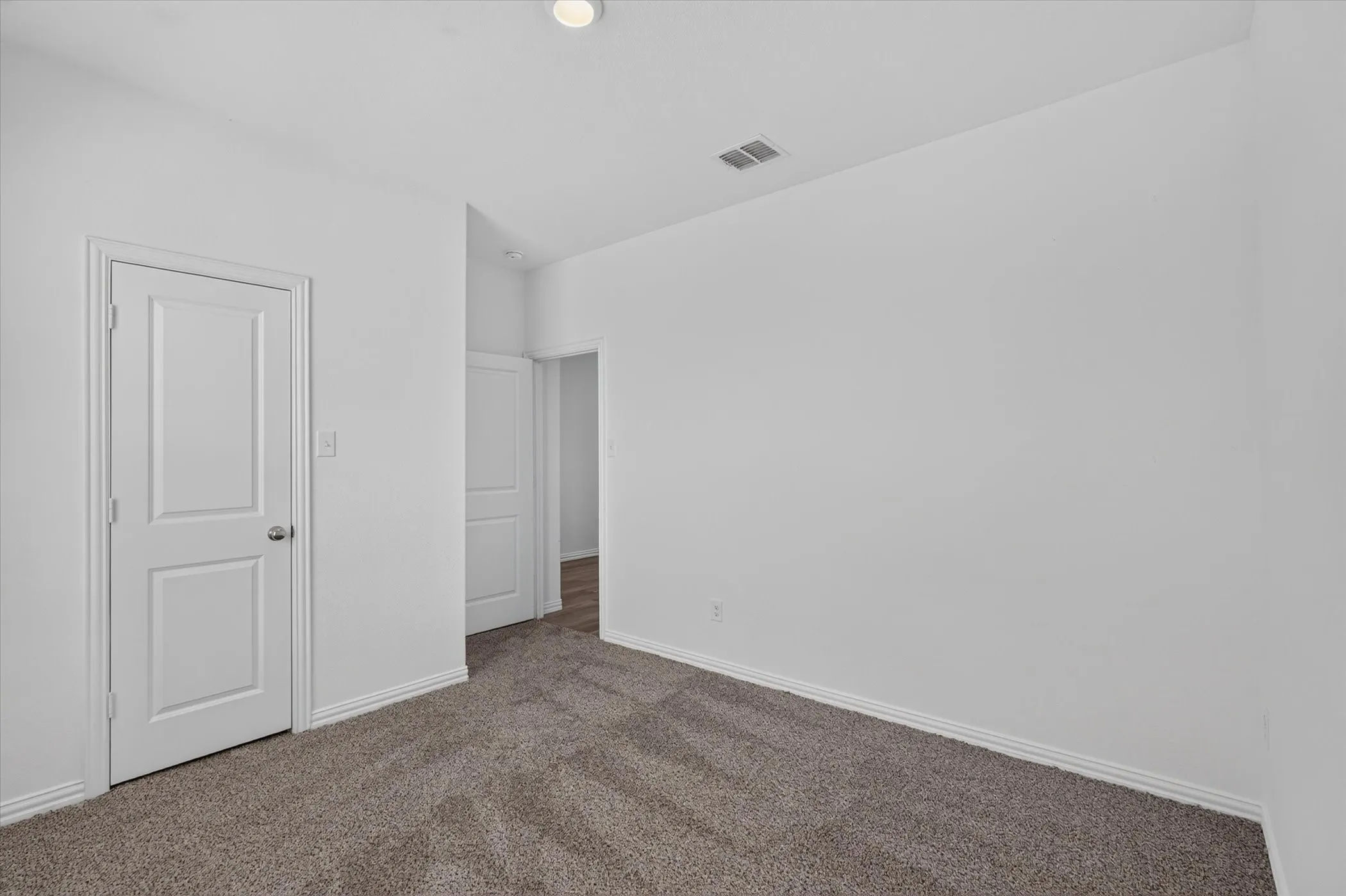 Spacious bedroom featuring neutral walls, recessed ceiling lighting, and soft carpet flooring