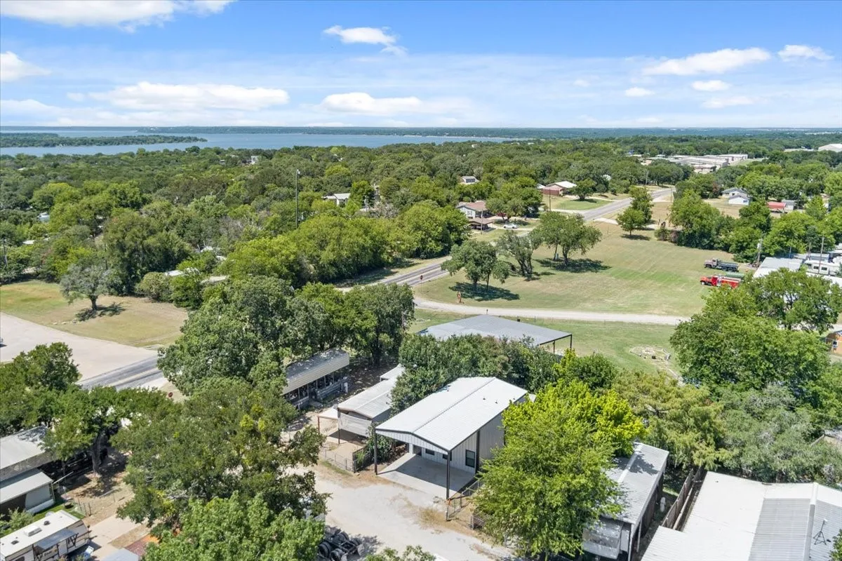 Aerial perspective showcasing a two-story structure with a metal roof and an attached carport