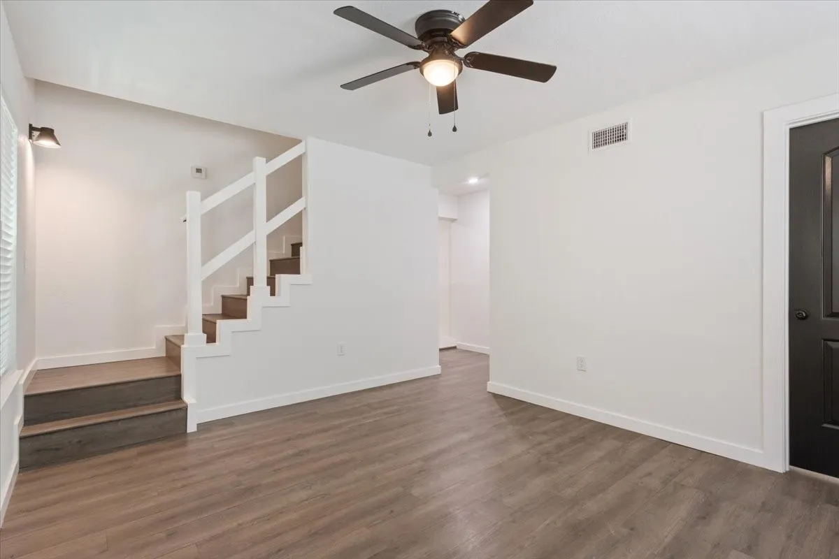 Living Room picture 1, by first primary bedroom. Showing staircase and entry to kitchen.