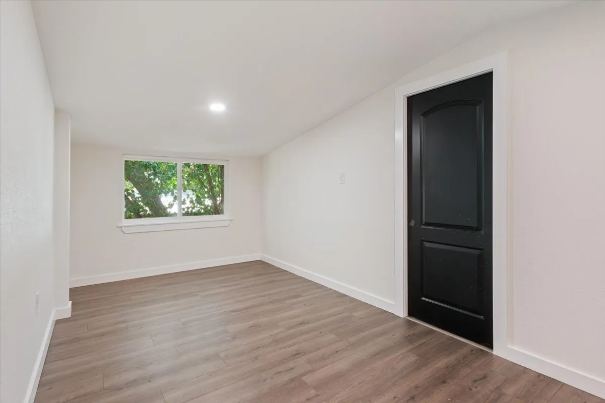 Second primary bedroom (upstairs) #1. Spacious room with wood-finish flooring, white baseboards, and a recessed ceiling light