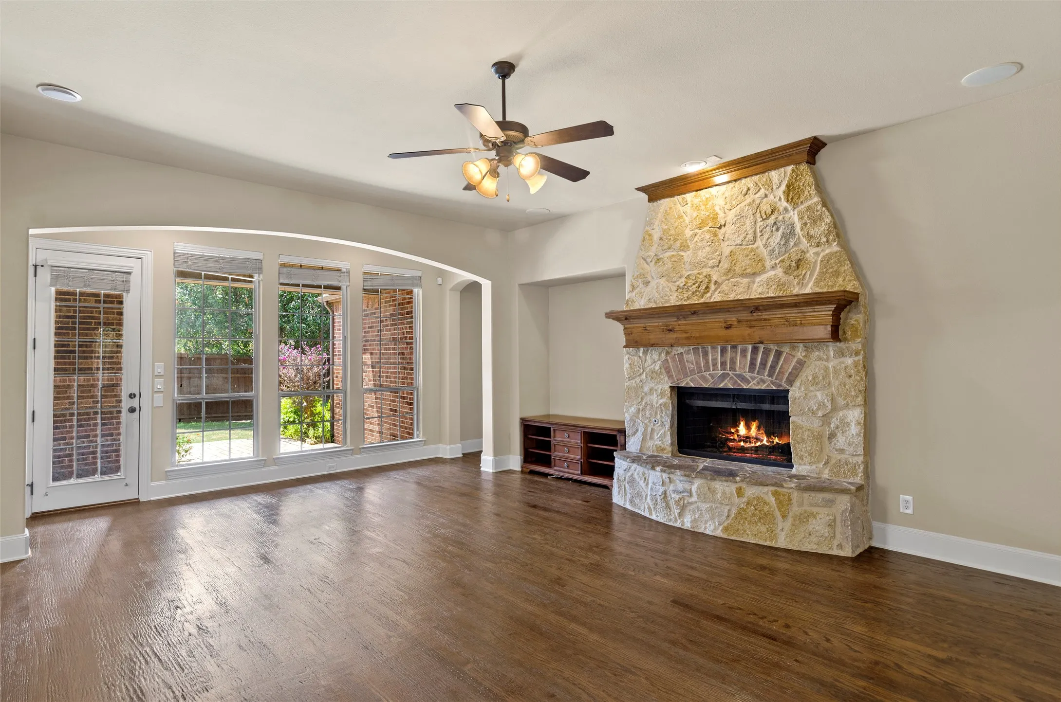 Stone fireplace with a brick firebox and wood mantel