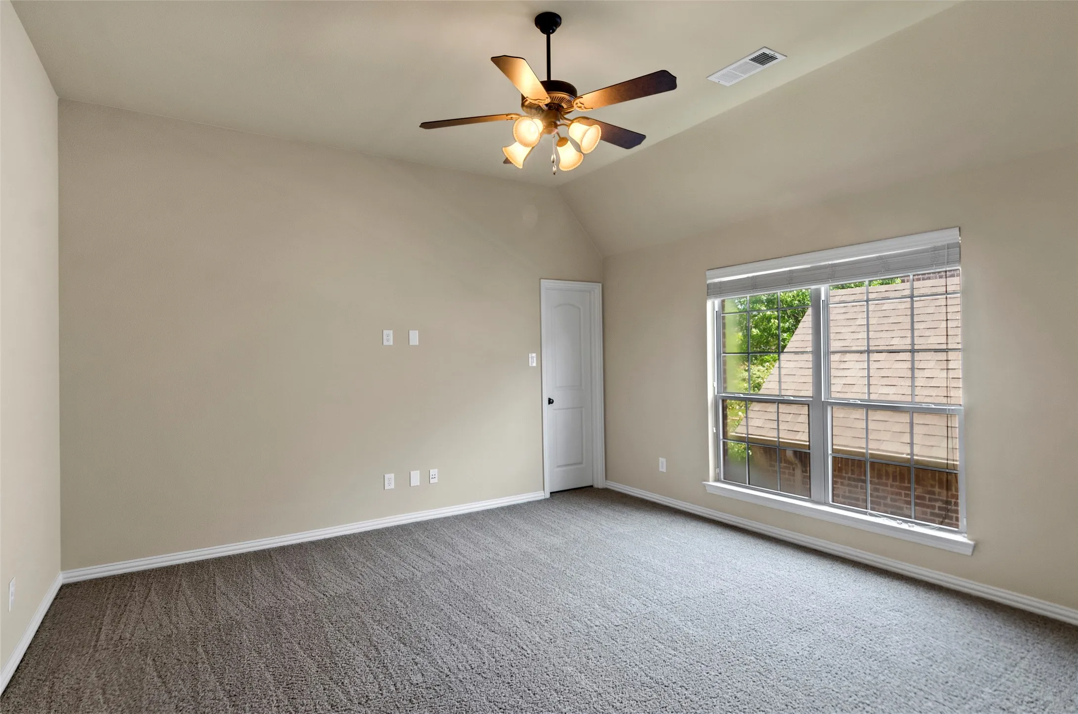 Room featuring neutral carpeting, a vaulted ceiling, and a ceiling fan with integrated lighting