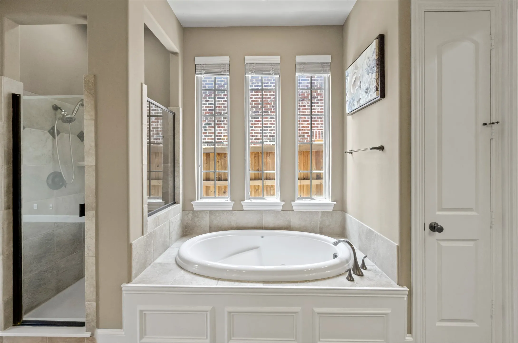 Built-in soaking tub with surround featuring paneled wainscoting and tile countertop