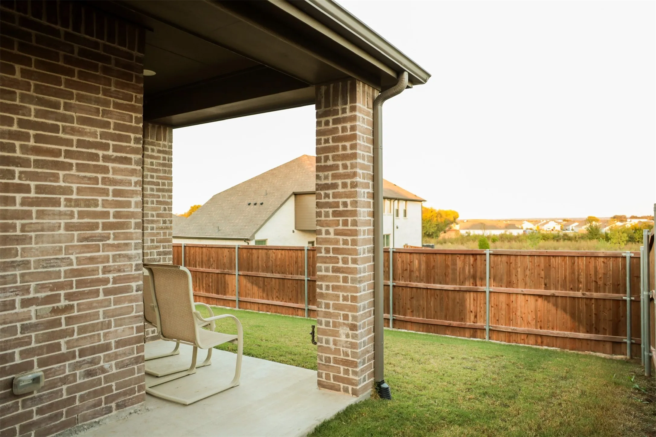 Covered patio featuring a concrete slab and brick columns