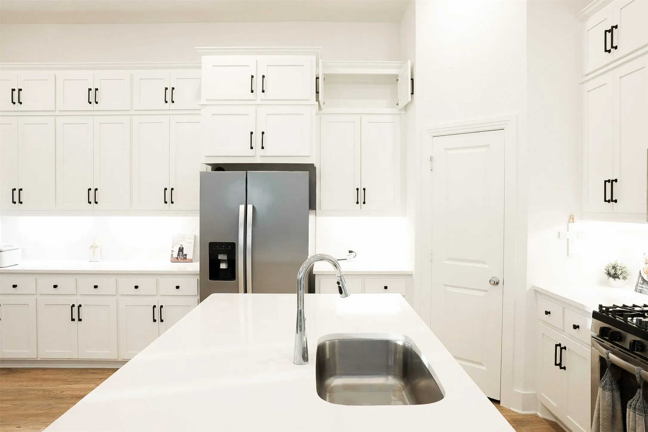 Spacious kitchen featuring an expansive island with an undermount sink and gooseneck faucet
