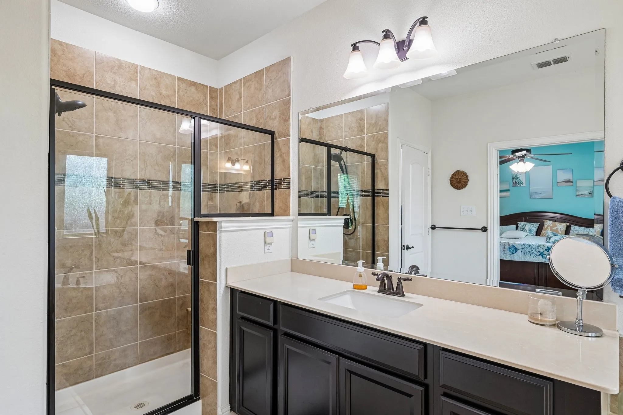 Bathroom featuring a walk-in shower with tile surround, glass enclosure, and black hardware