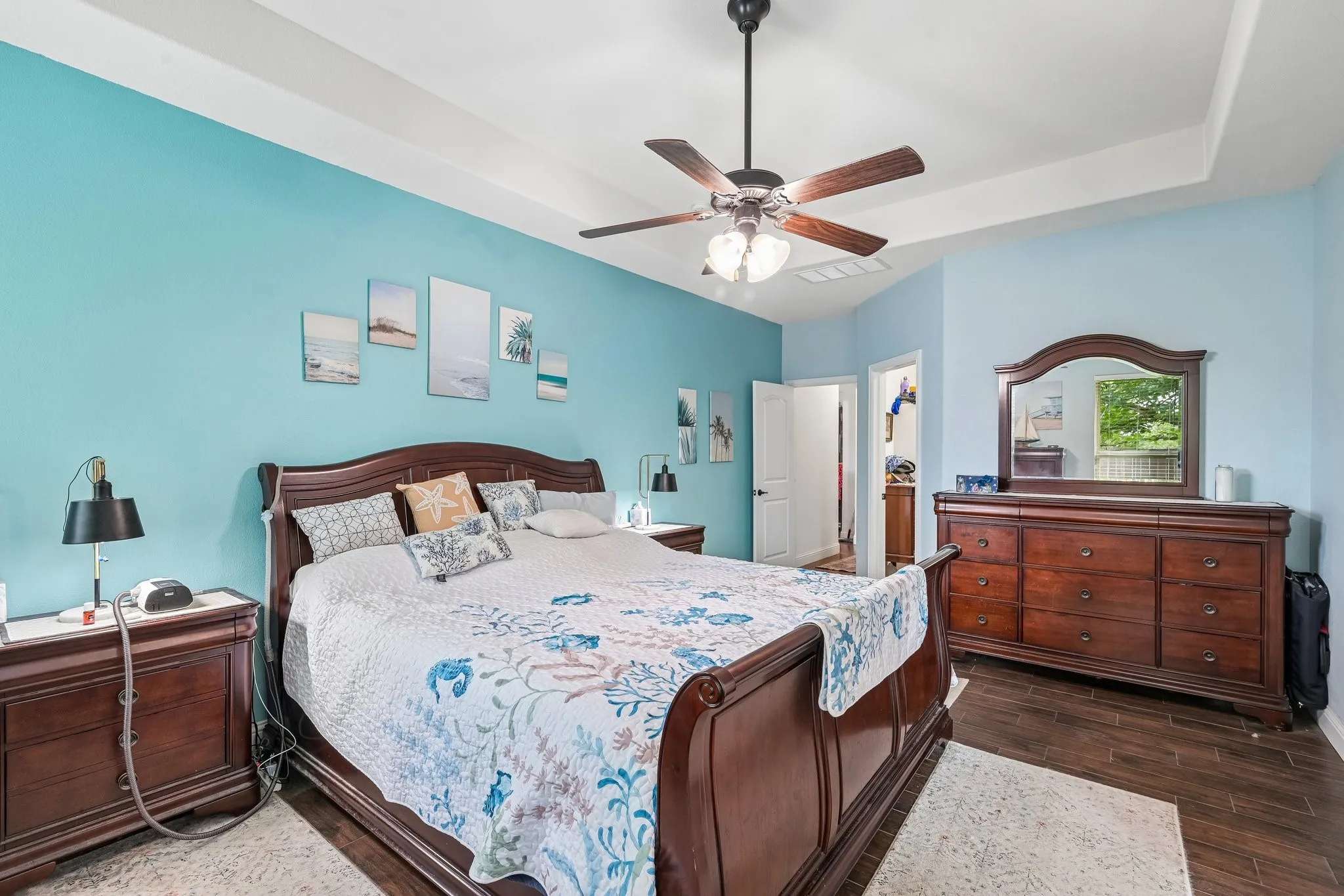 Spacious bedroom with a tray ceiling and a ceiling fan