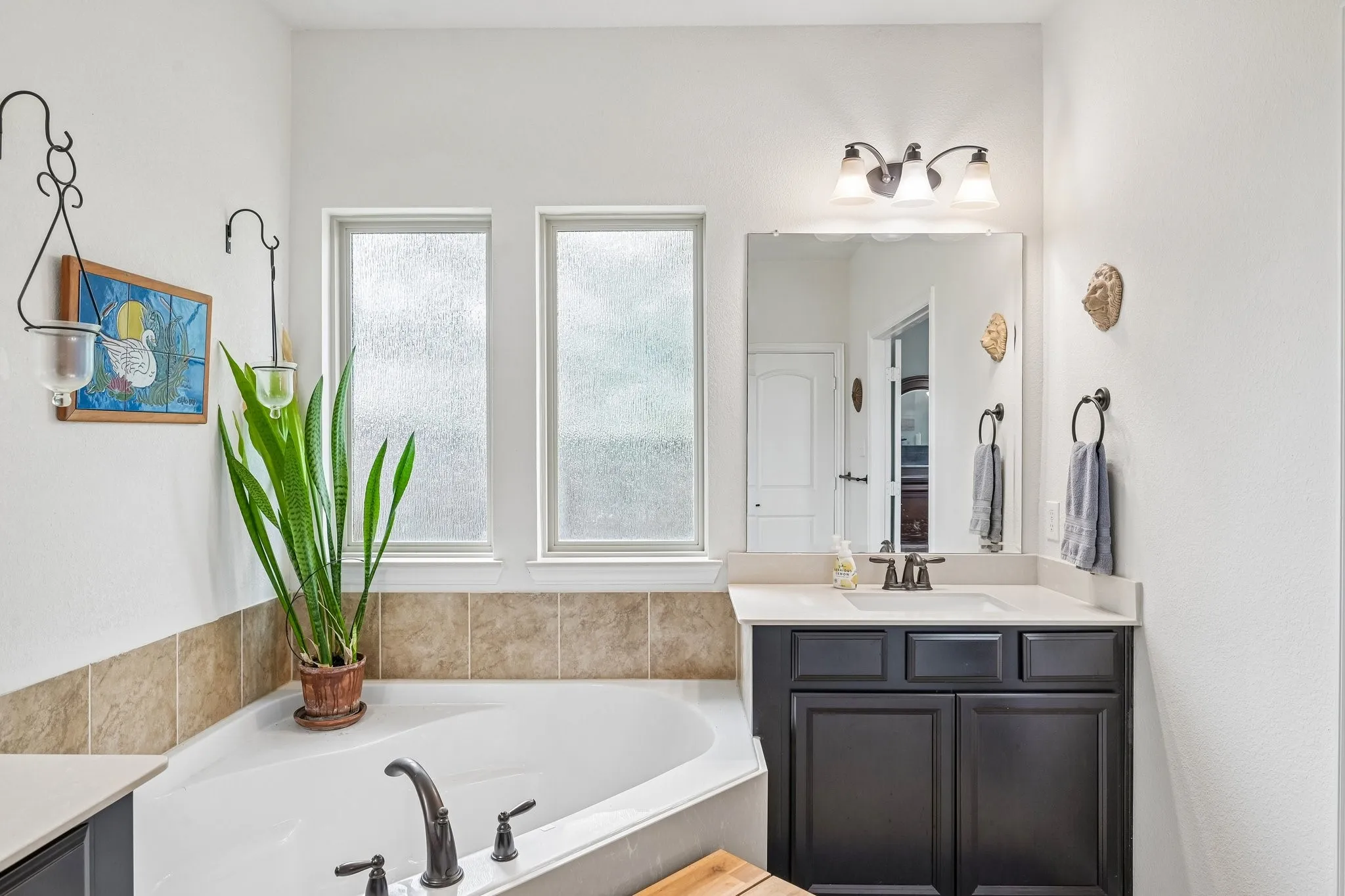 Corner soaking tub featuring an antique bronze finish faucet