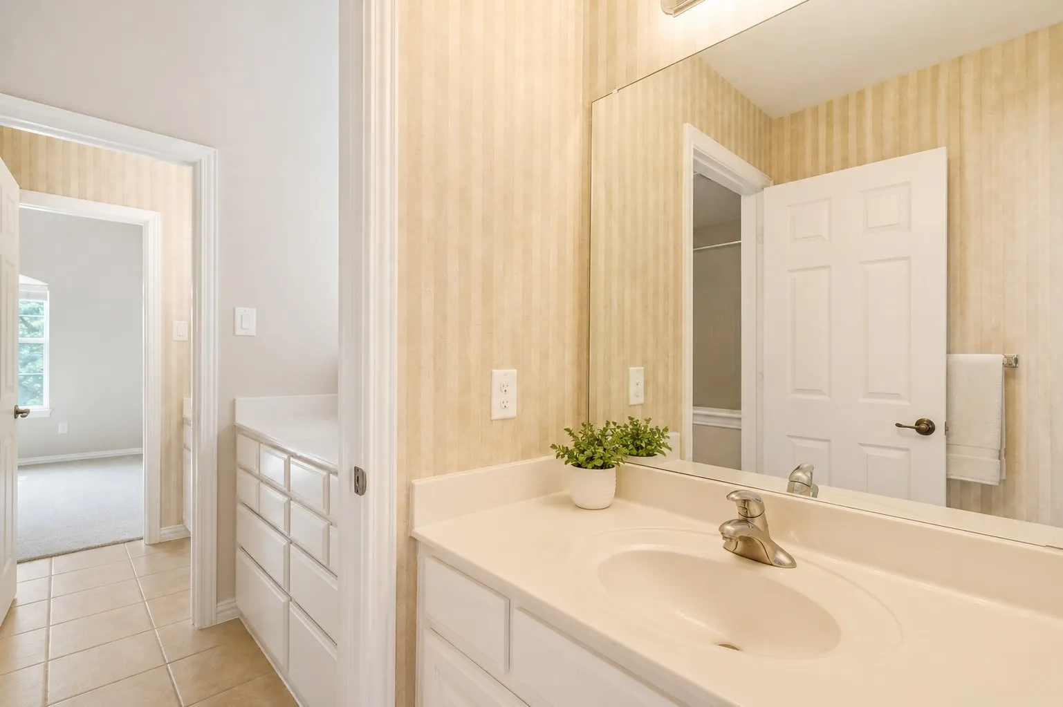 Vanity area featuring a built-in single sink with brushed nickel faucet, large wall mirror, and integrated storage cabinetry