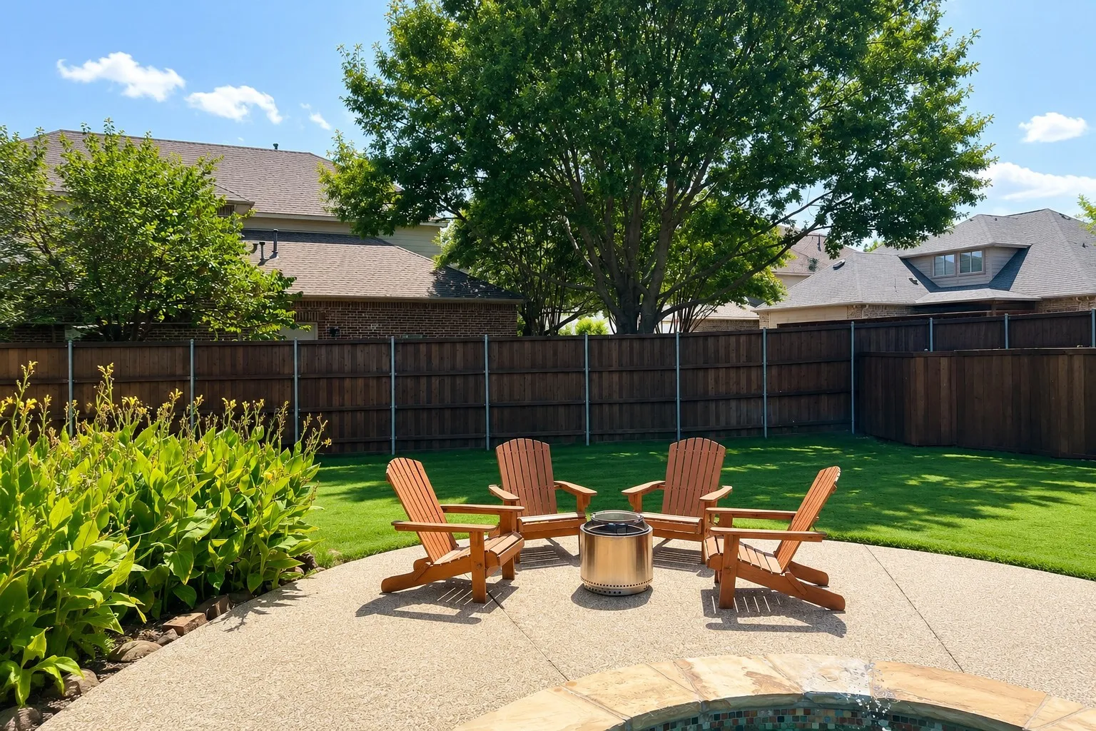 Backyard featuring a circular aggregate patio, lush green lawn, mature trees, and a privacy fence
