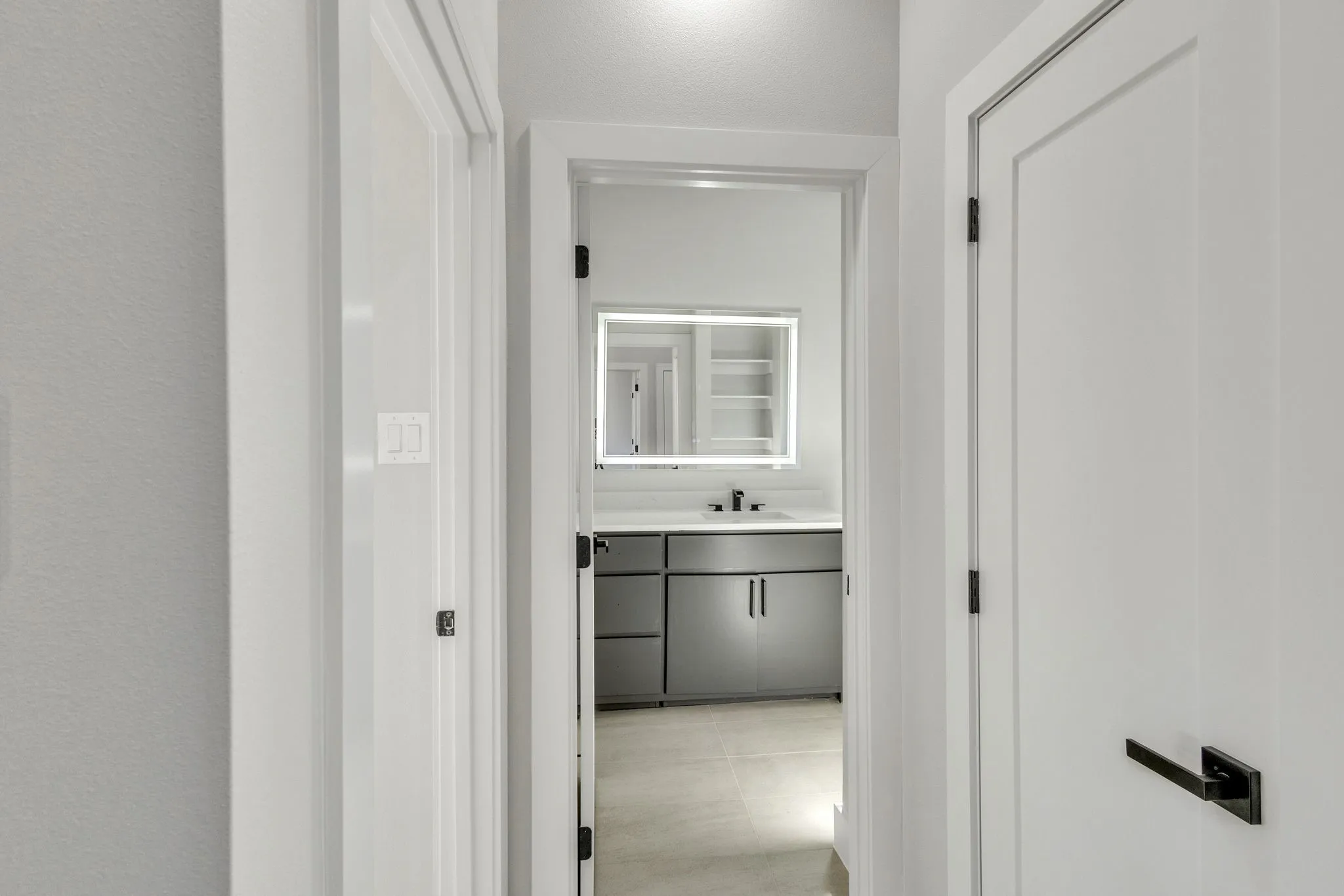 Corridor with sink and light tile patterned flooring
