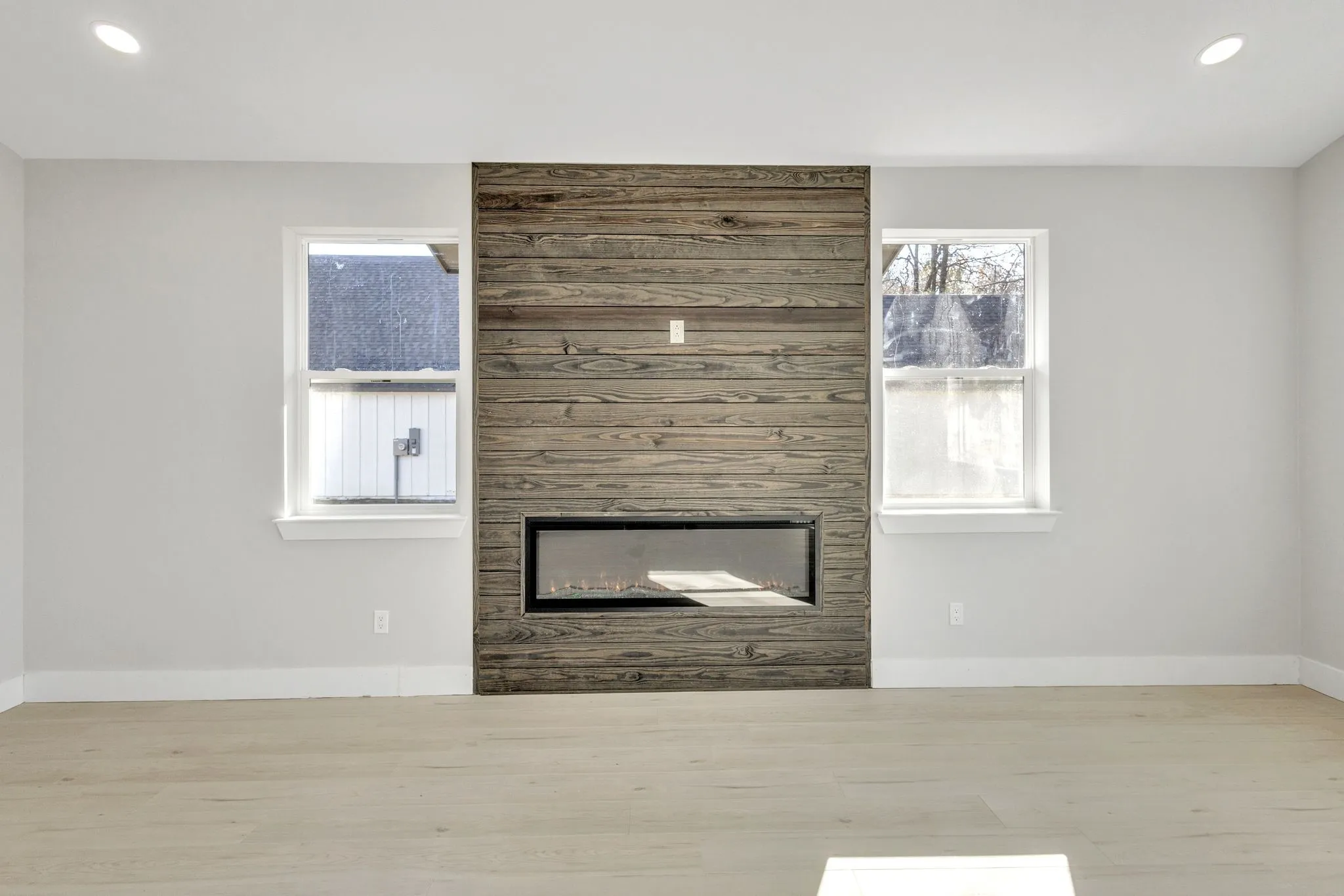 Unfurnished living room with light hardwood / wood-style floors and a large fireplace