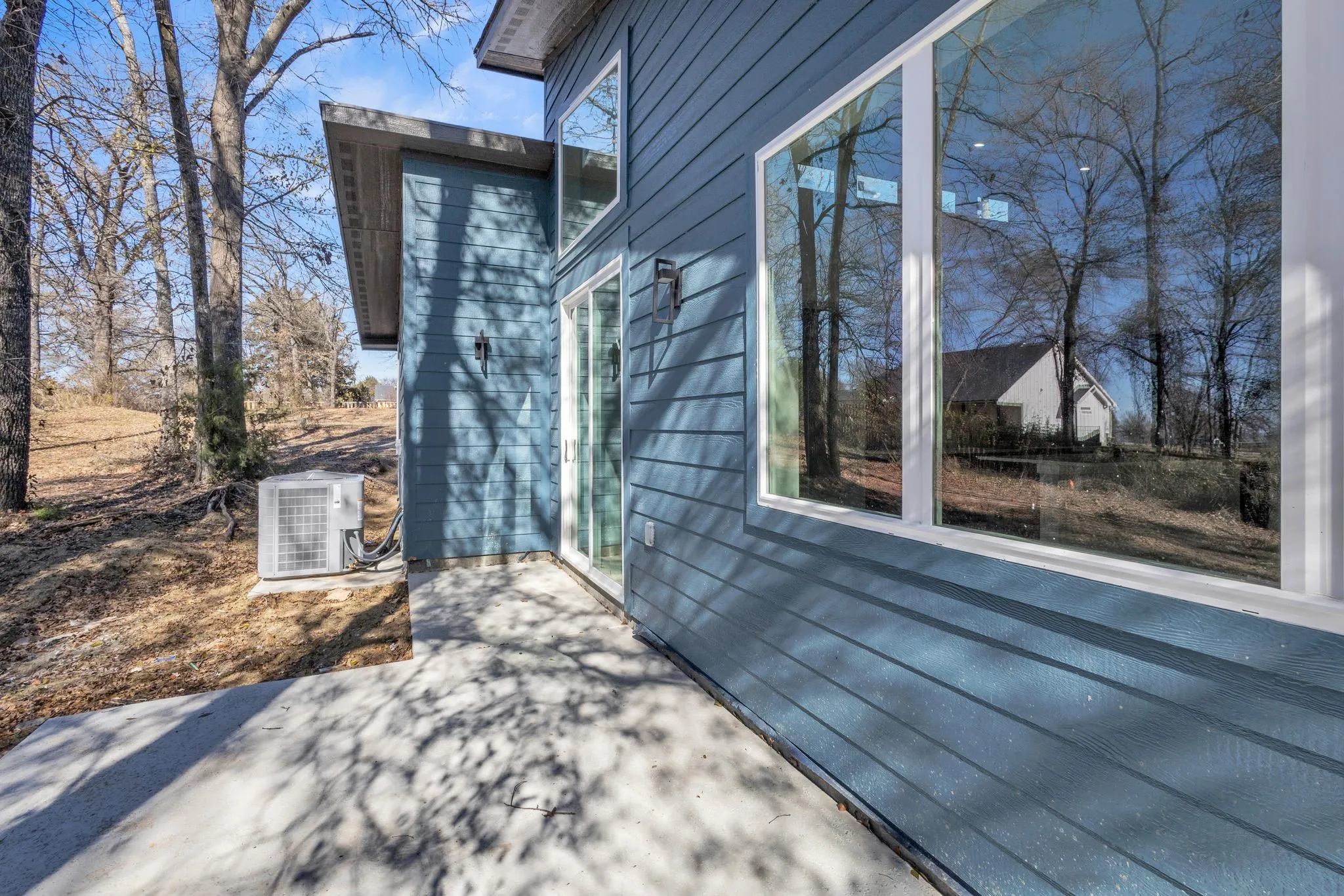 View of side of home featuring a patio area and central AC