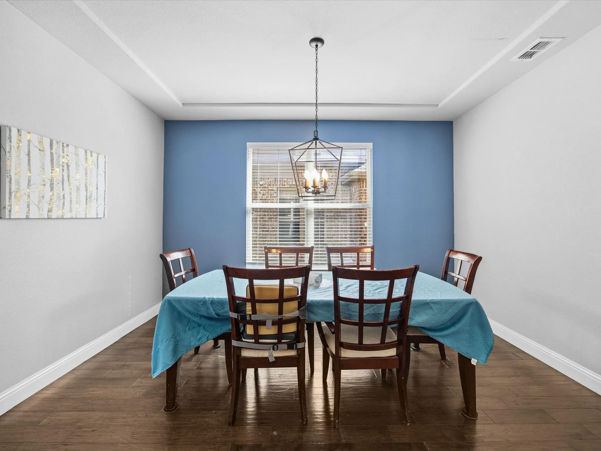 Dining room with dark wood finished floors and a chandelier
