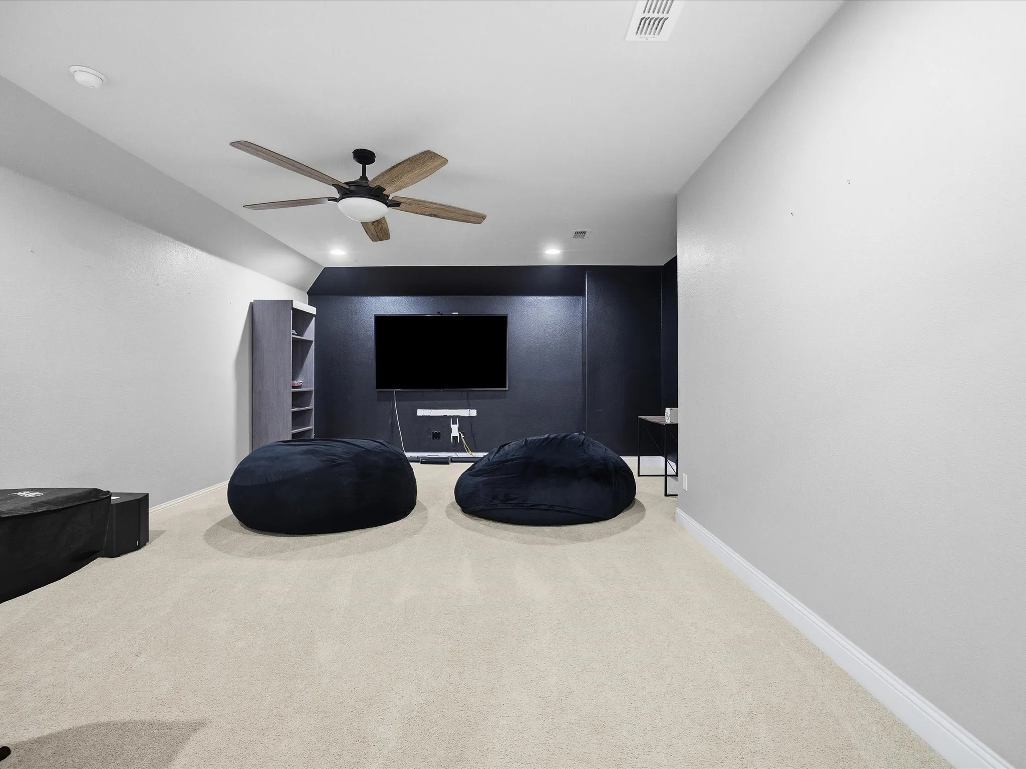 Carpeted cinema room featuring a ceiling fan and recessed lighting