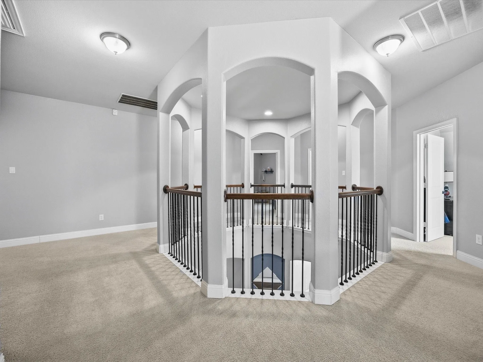 Hallway with carpet floors and an upstairs landing