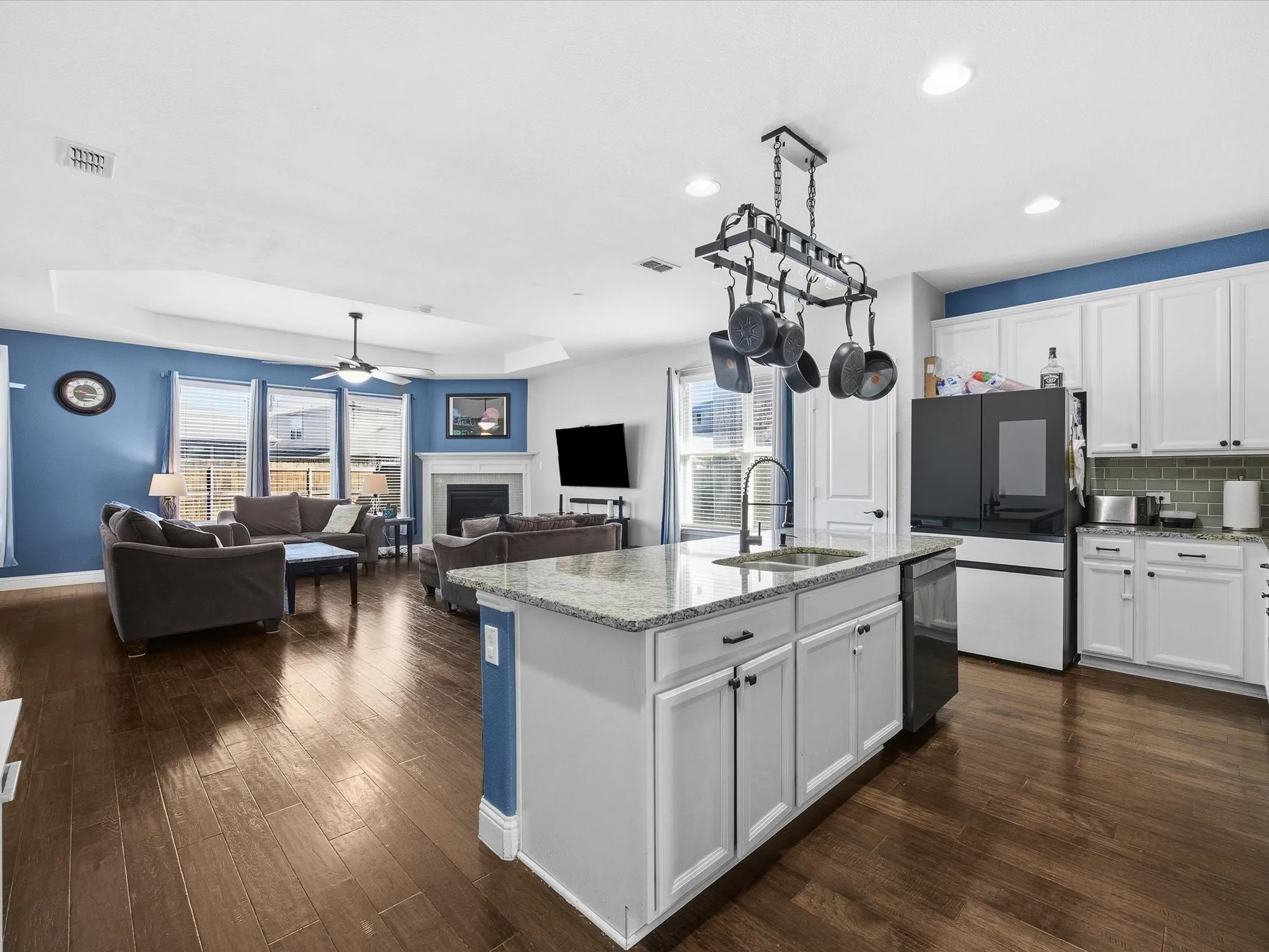 Kitchen featuring white cabinets, a fireplace, light stone counters, a tray ceiling, and smart refrigerator