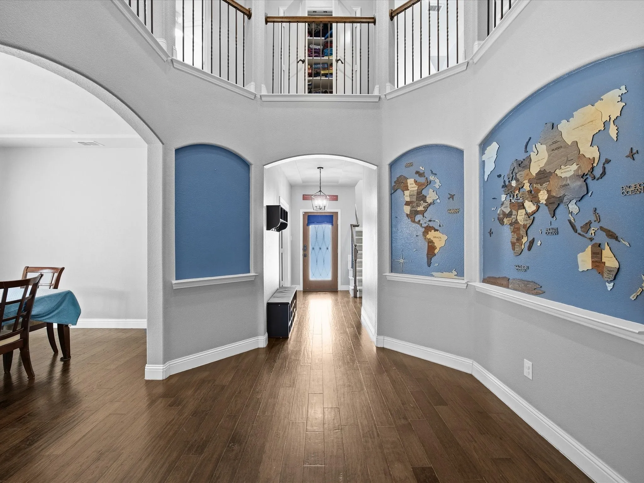Foyer entrance featuring a high ceiling, arched walkways, and dark wood-type flooring
